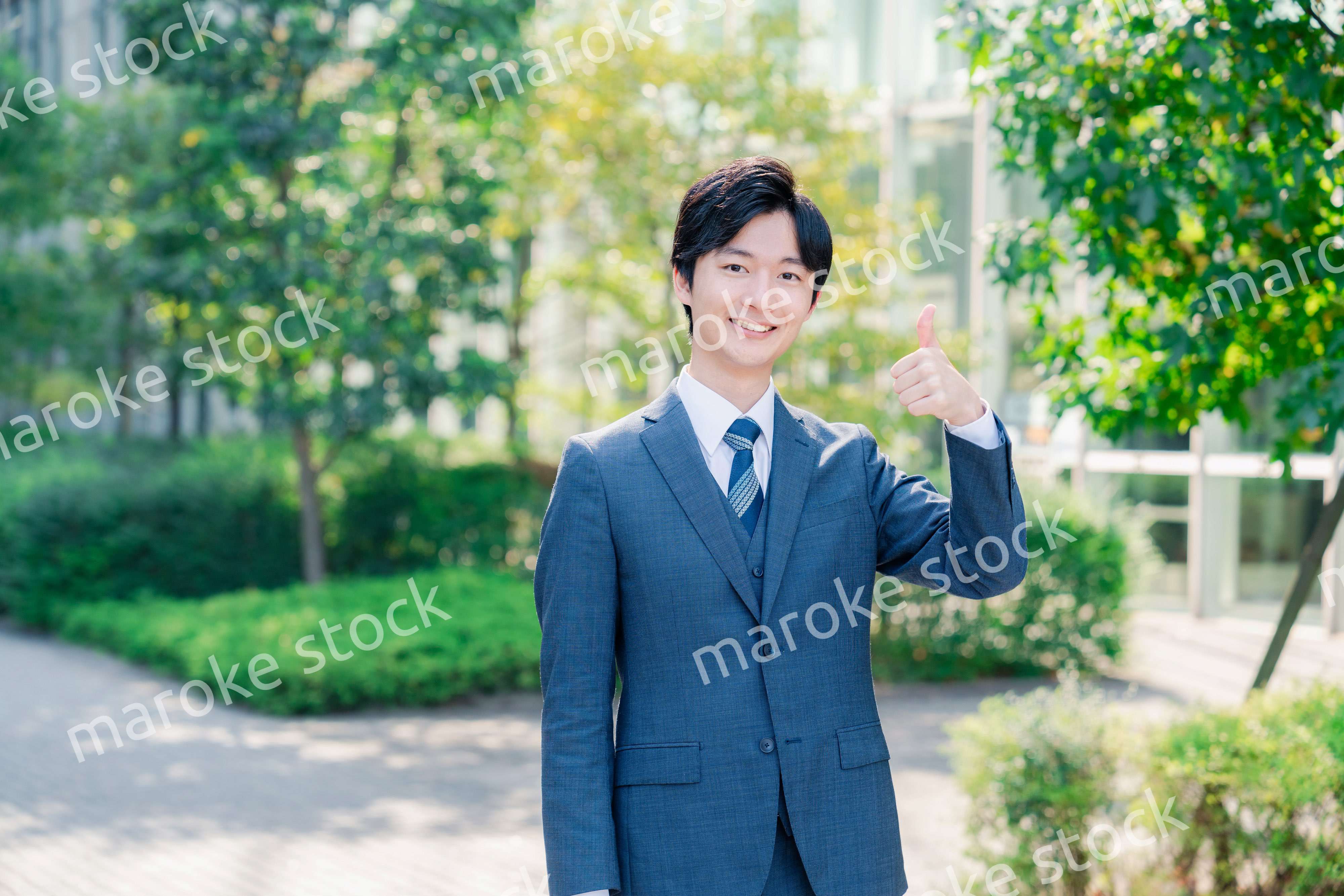 笑顔でOKサインをする若いビジネスマン