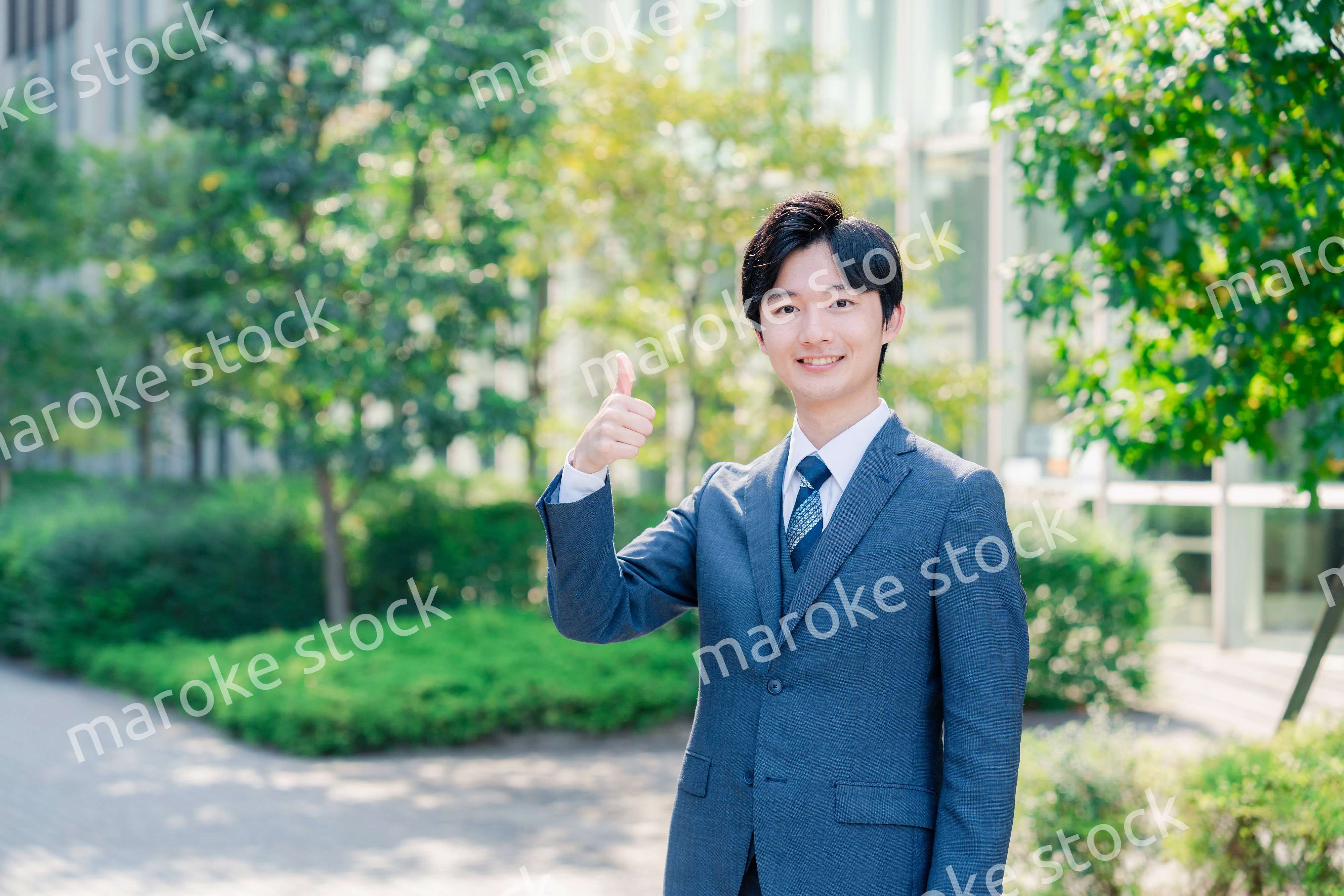 笑顔でOKサインをする若いビジネスマン