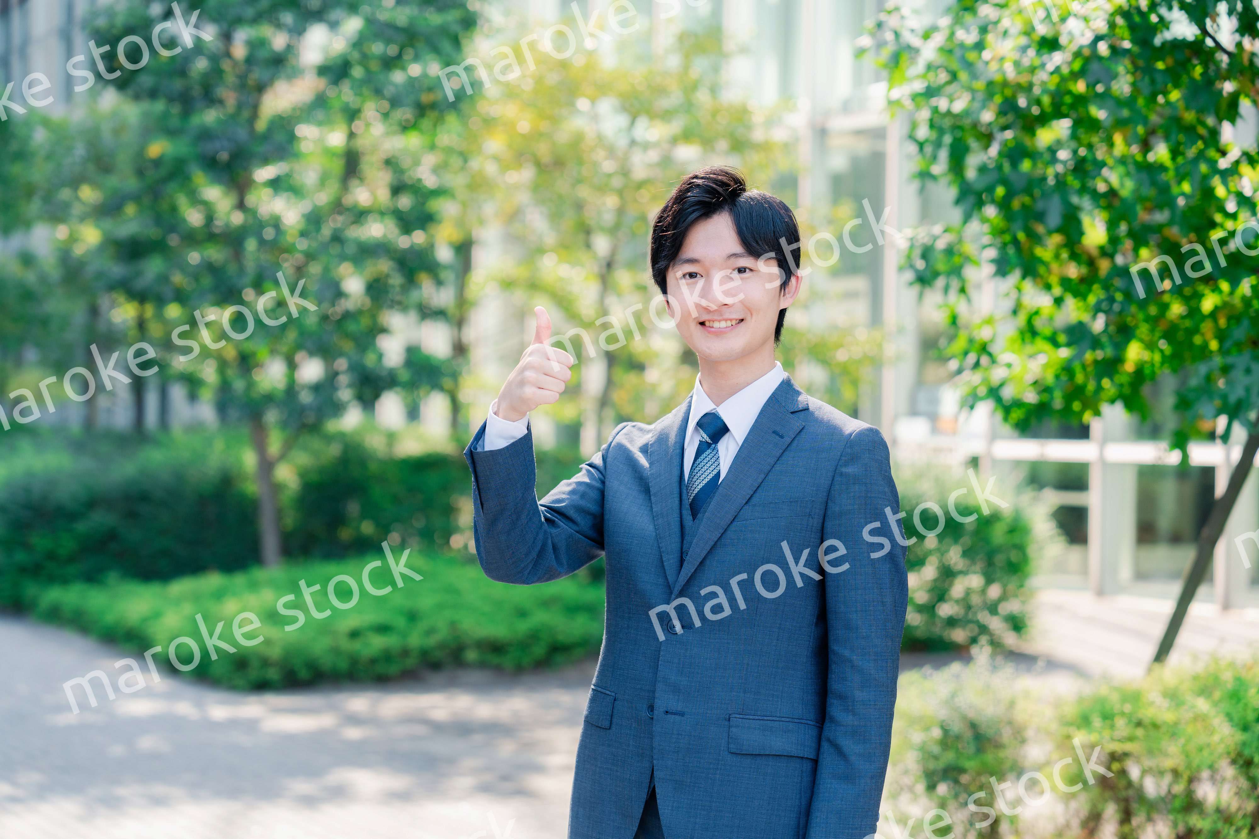 笑顔でOKサインをする若いビジネスマン