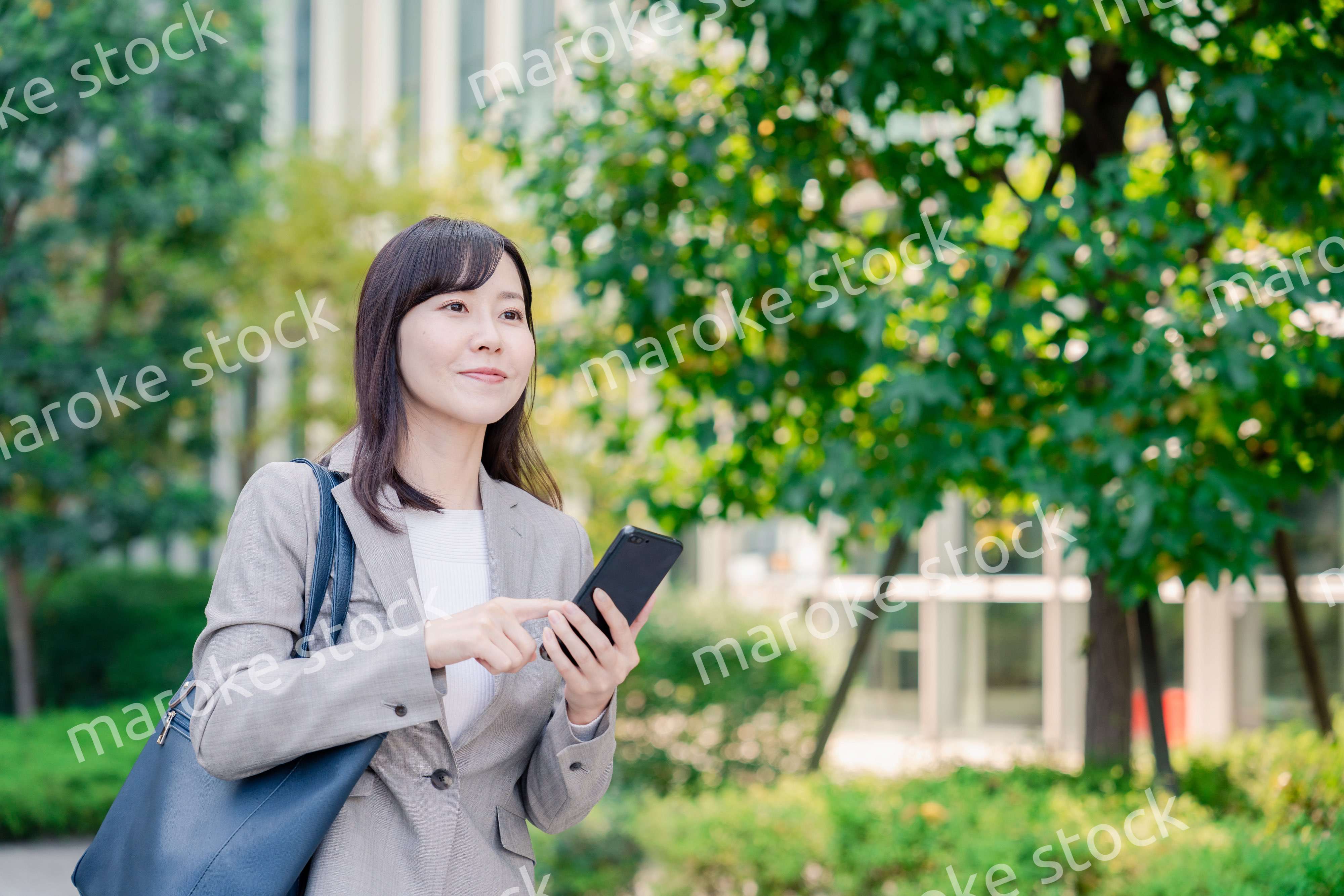 スマホを使いながら歩くビジネスウーマン