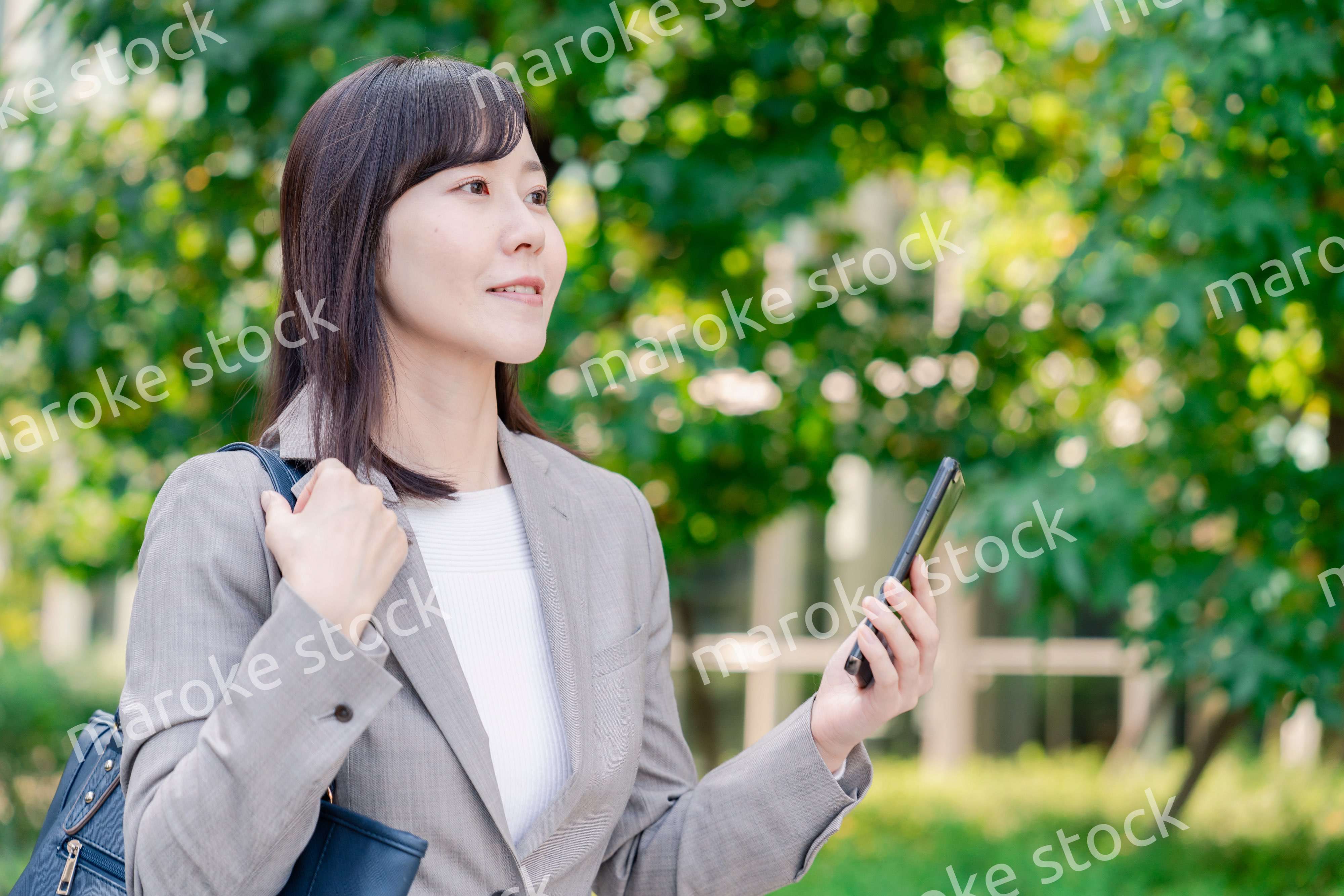 スマホを使いながら歩くビジネスウーマン