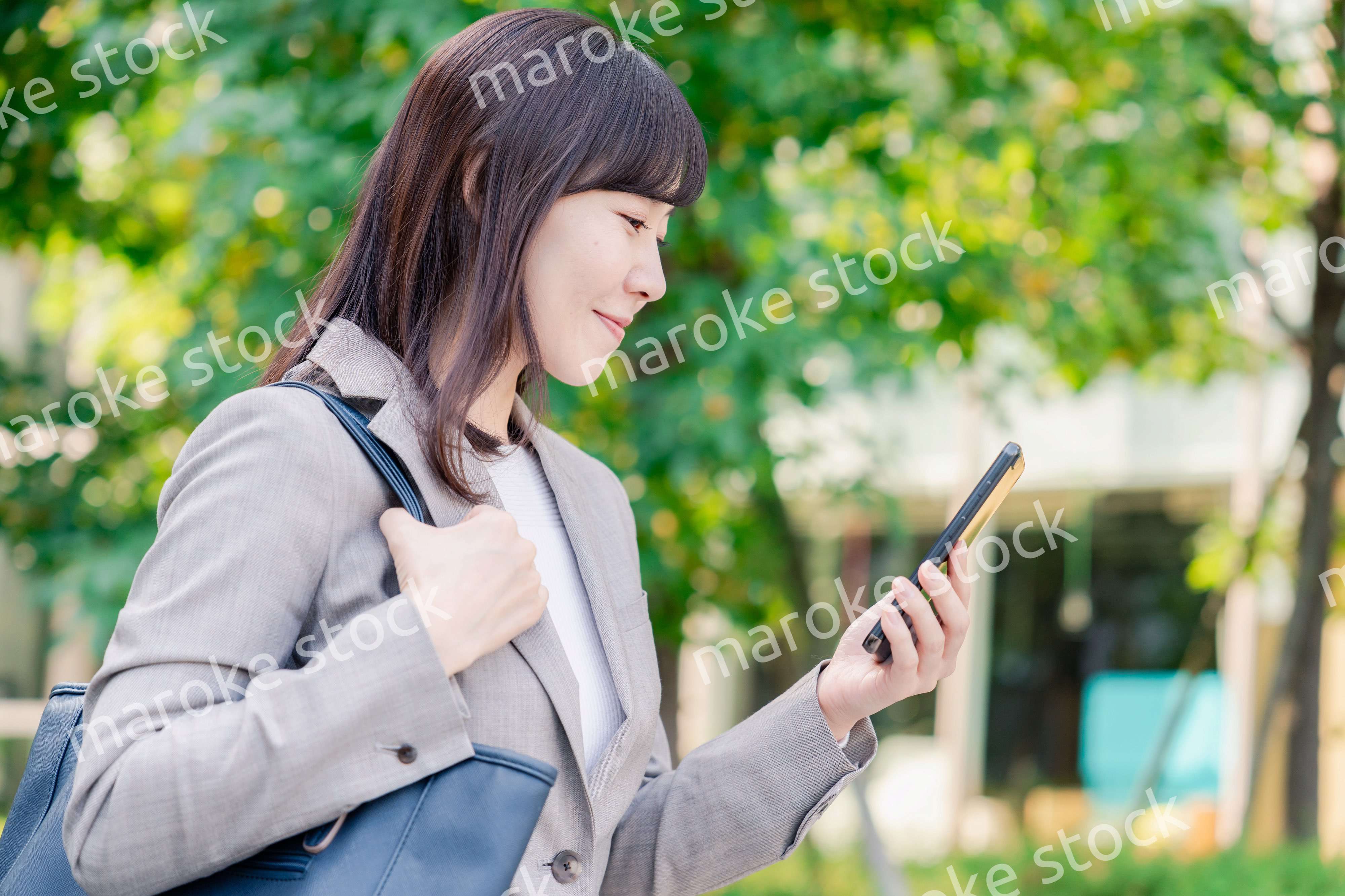 スマホを使いながら歩くビジネスウーマン