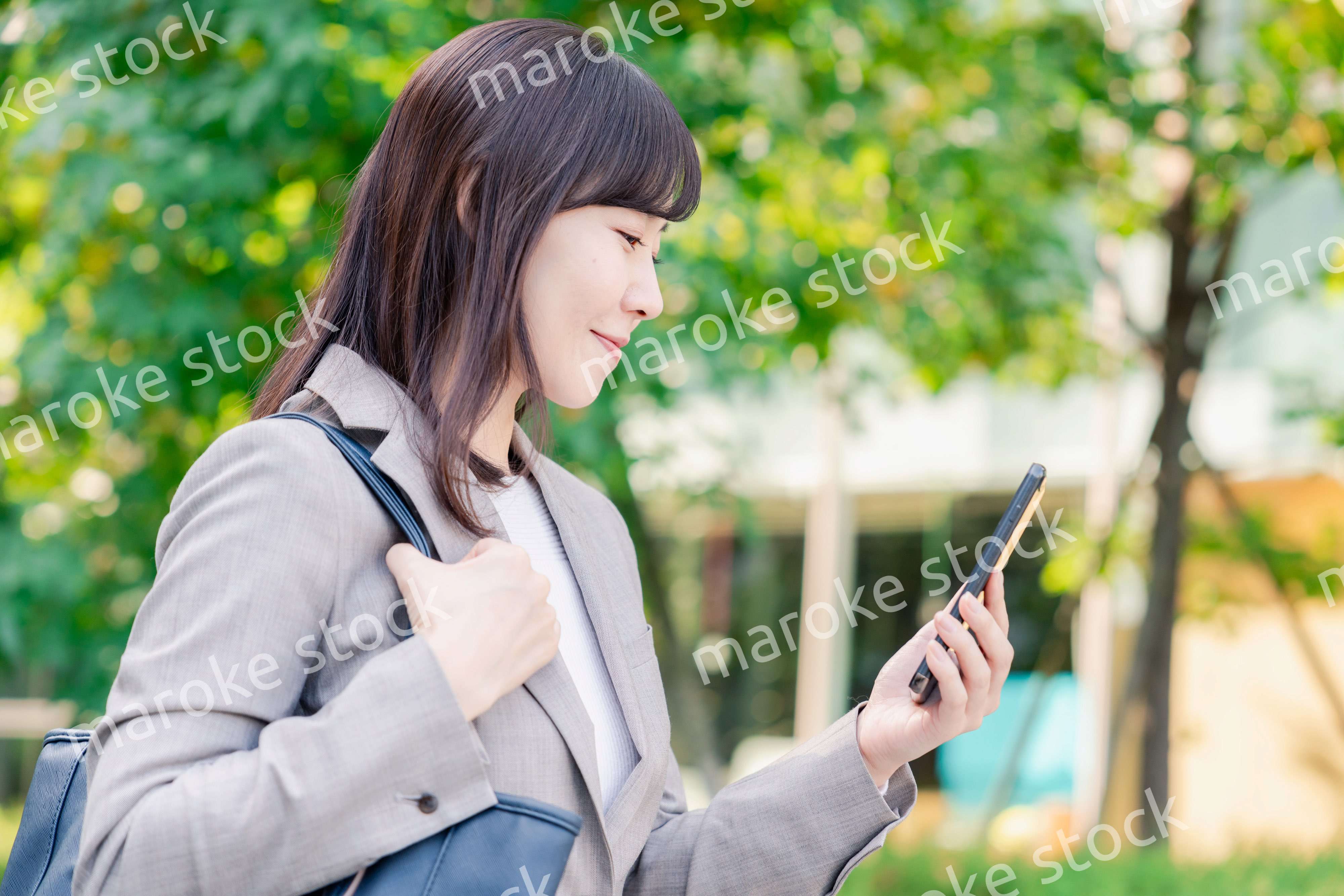 スマホを使いながら歩くビジネスウーマン