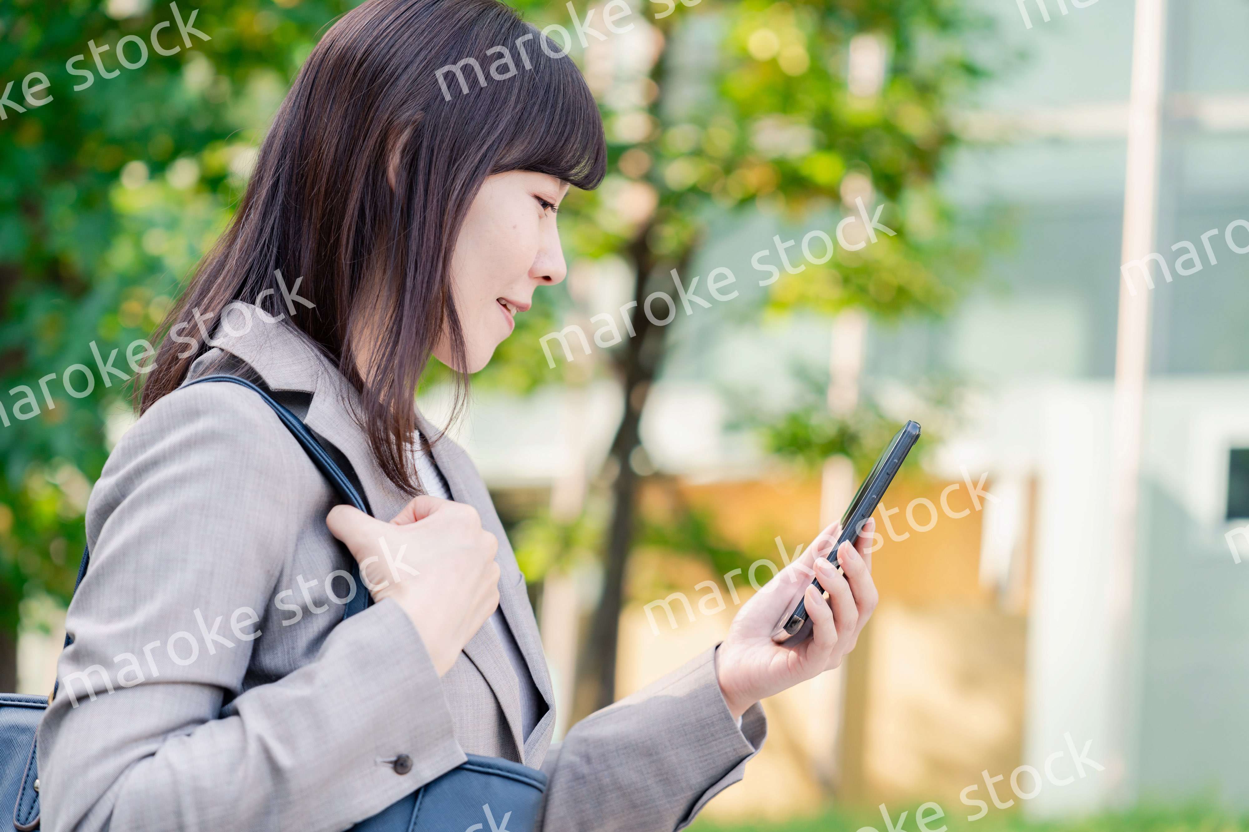 スマホを使いながら歩くビジネスウーマン