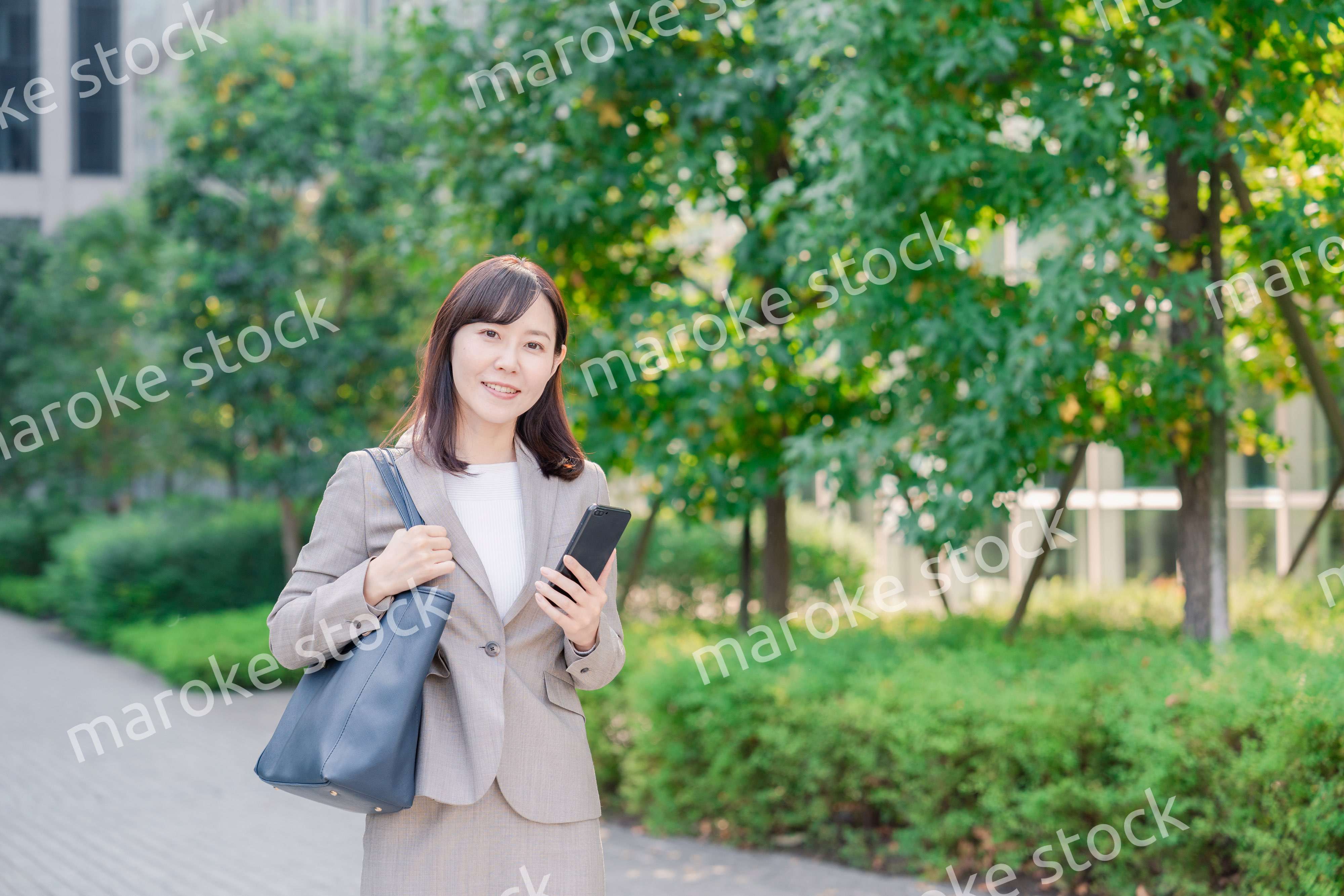 スマホを使いながら歩くビジネスウーマン