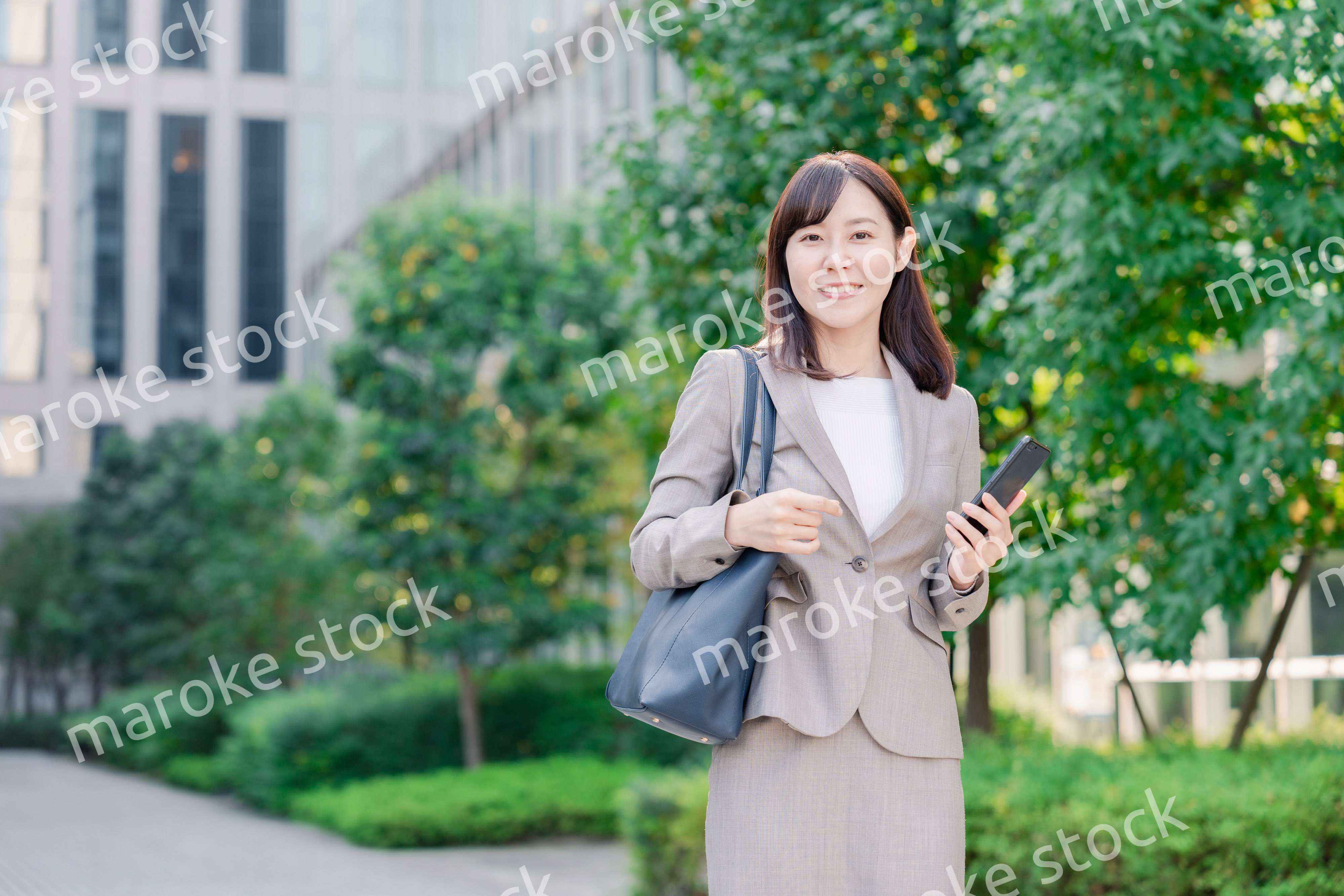 スマホを使いながら歩くビジネスウーマン