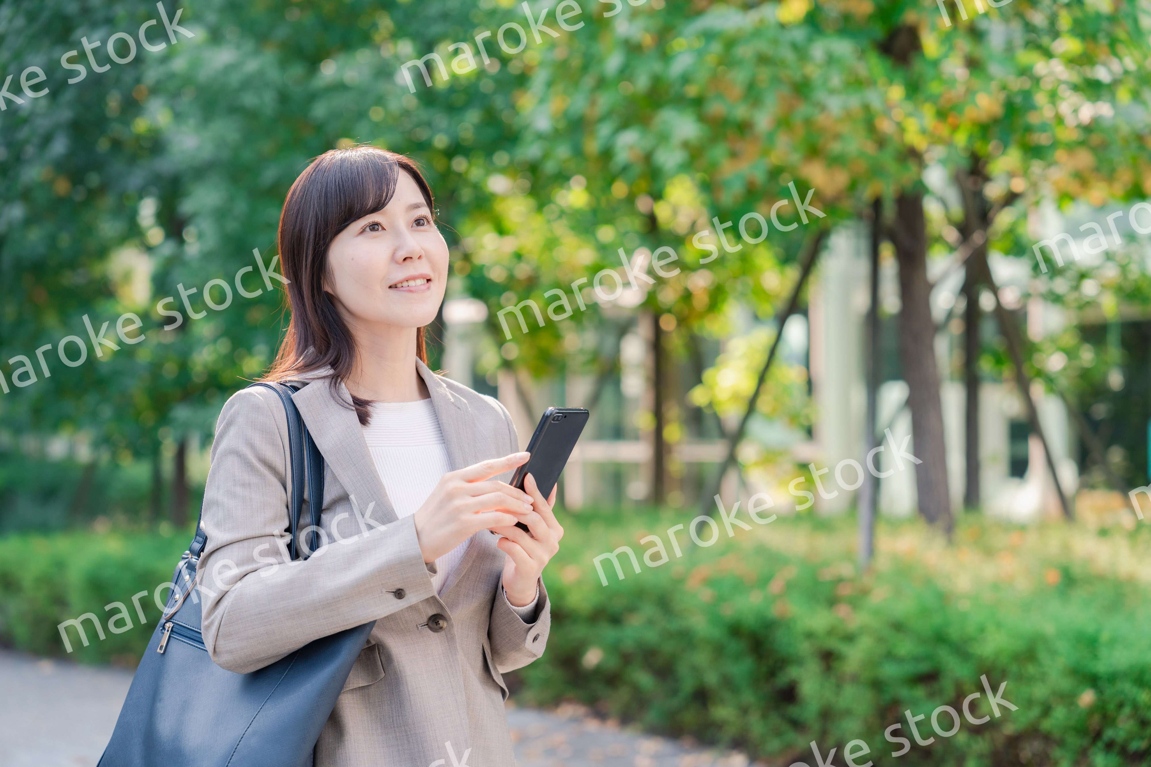 スマホを使いながら歩くビジネスウーマン