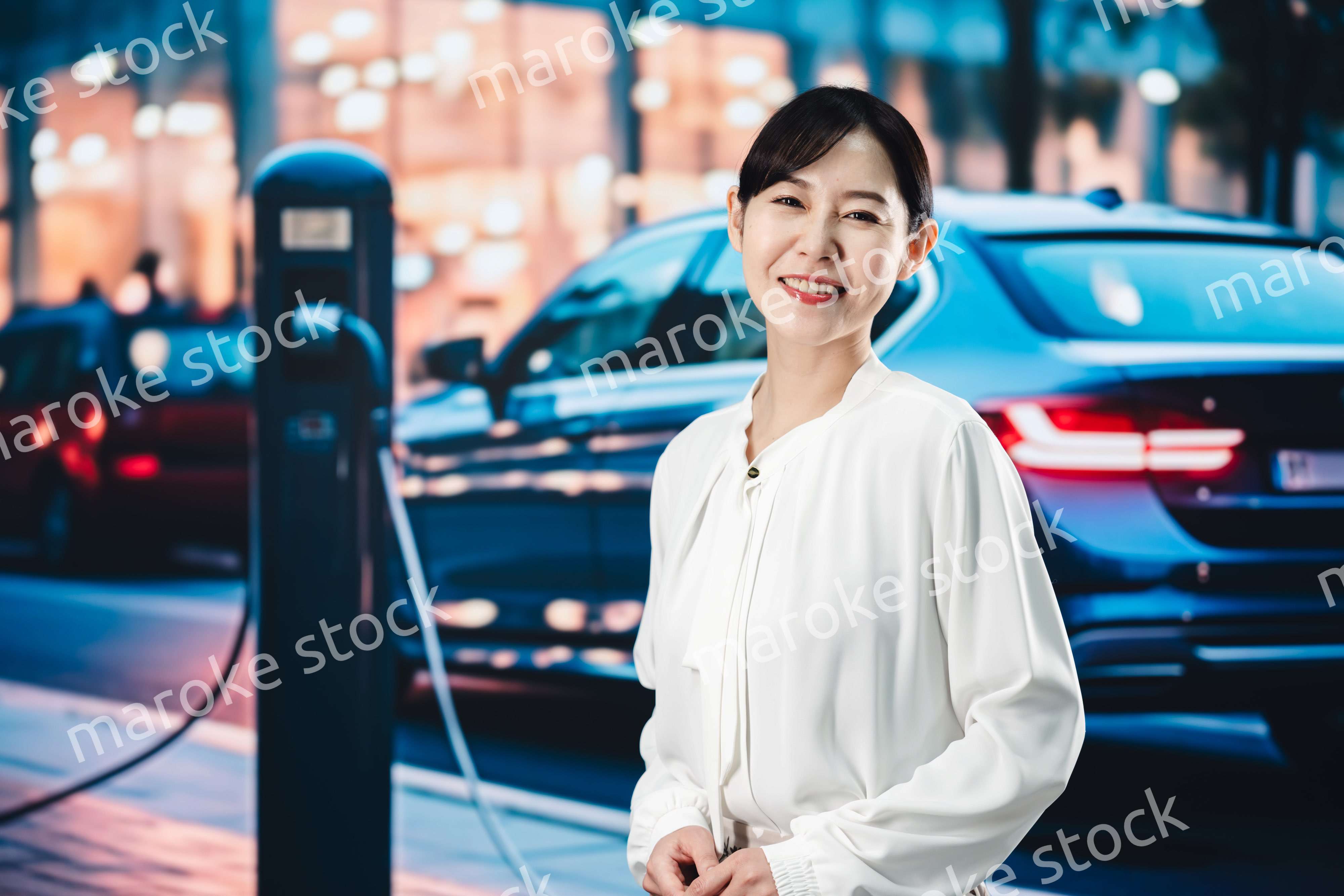 道路で電気自動車を充電する女性