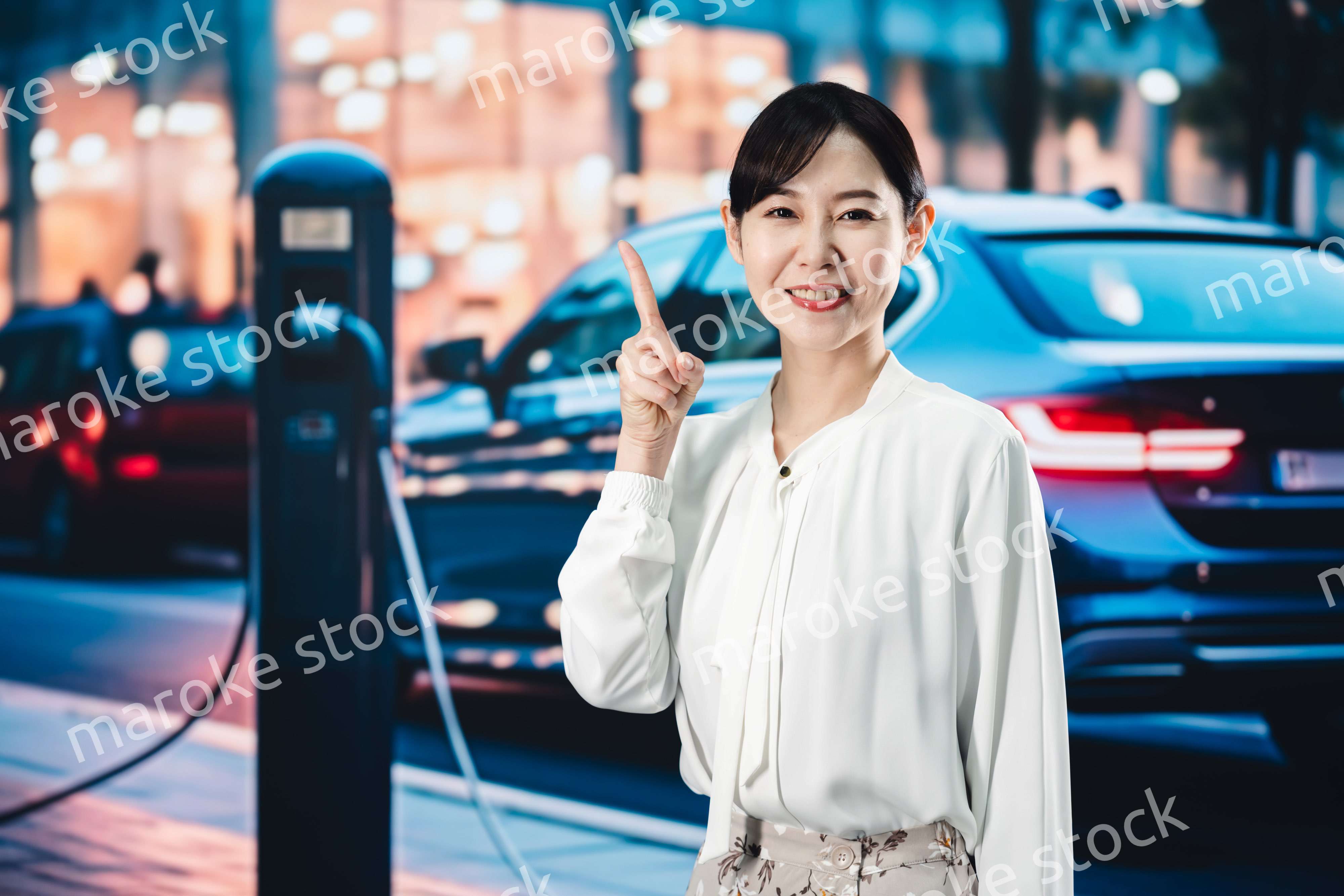 道路で電気自動車を充電する女性
