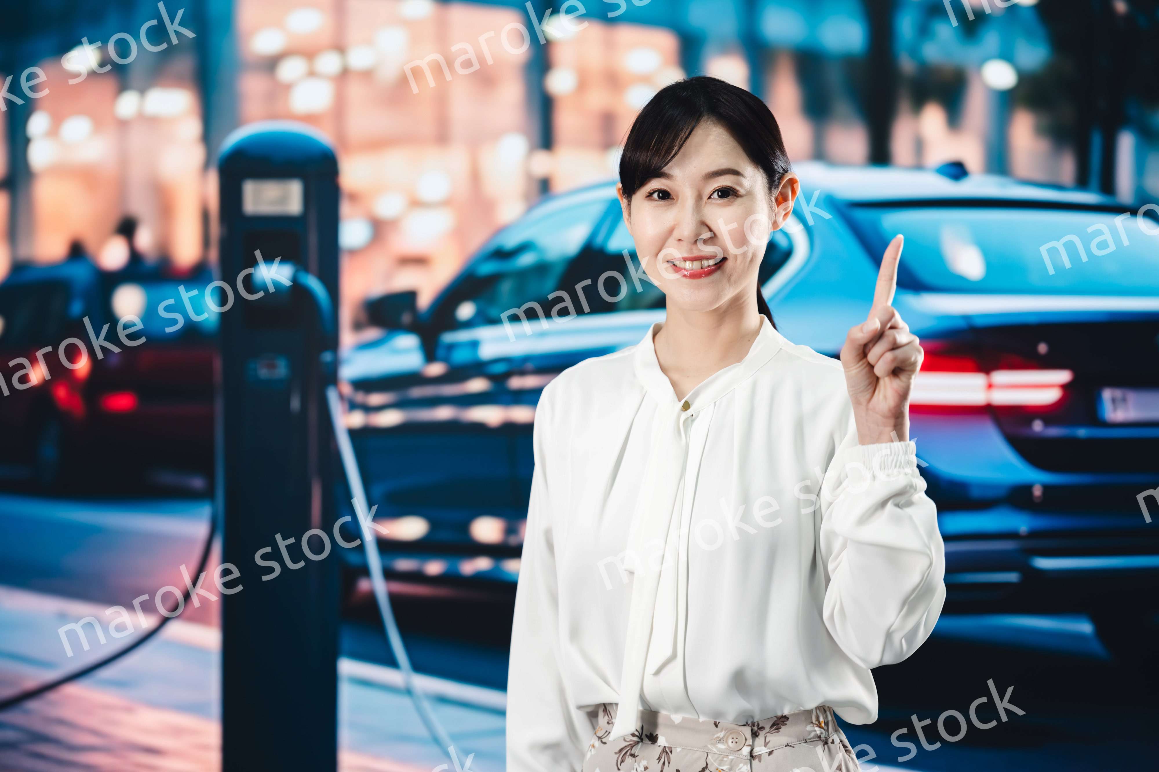 道路で電気自動車を充電する女性