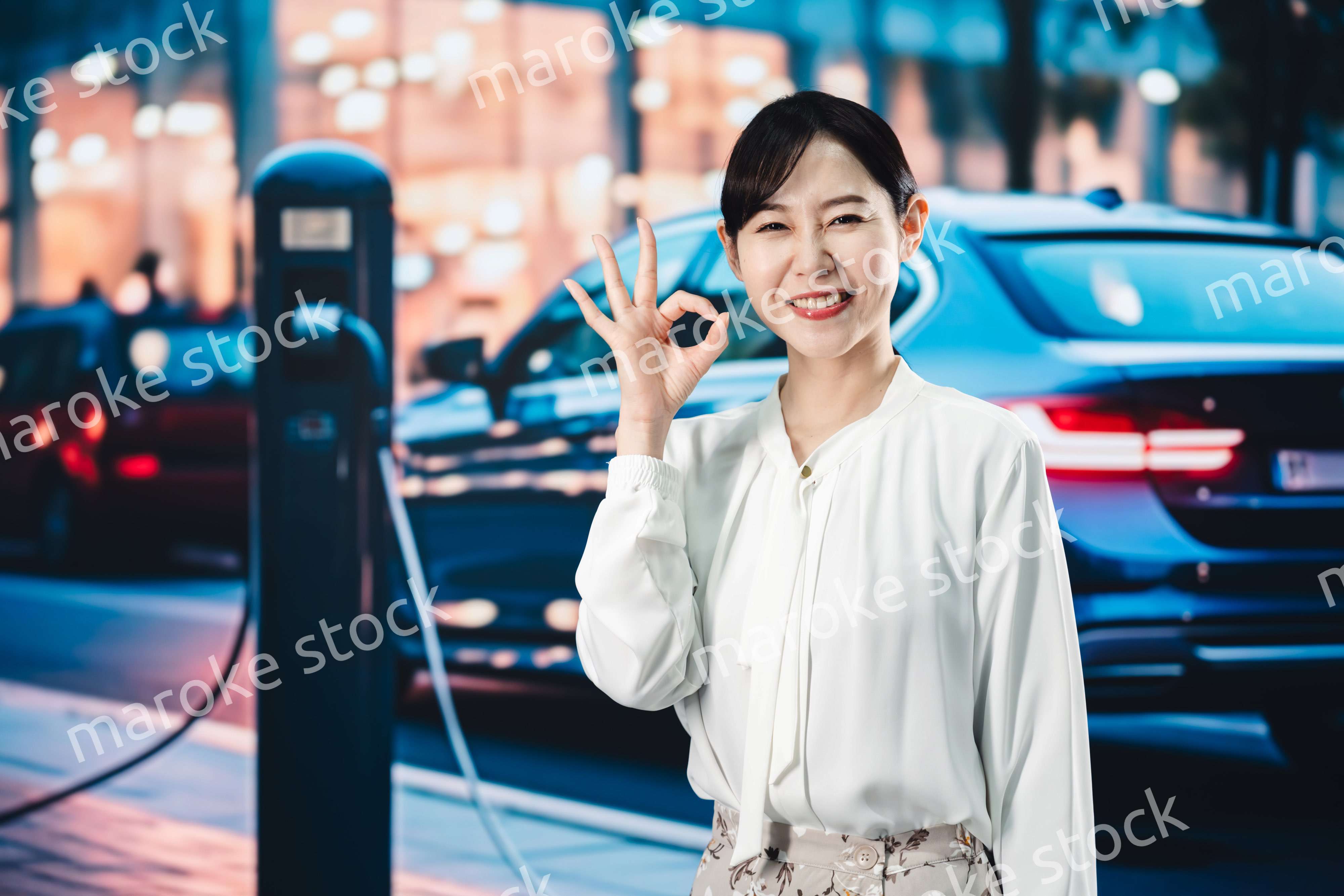 道路で電気自動車を充電する女性