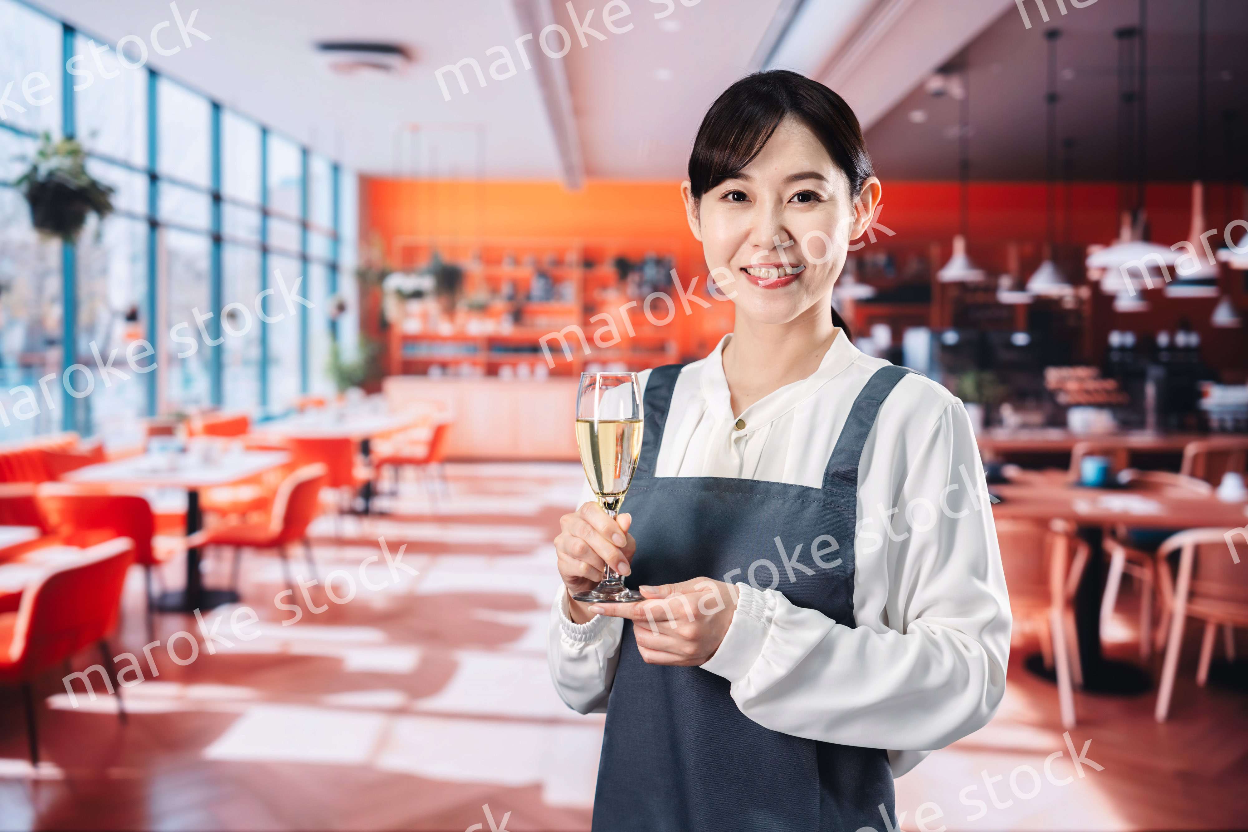 レストランでスパークリングワインを提供する女性