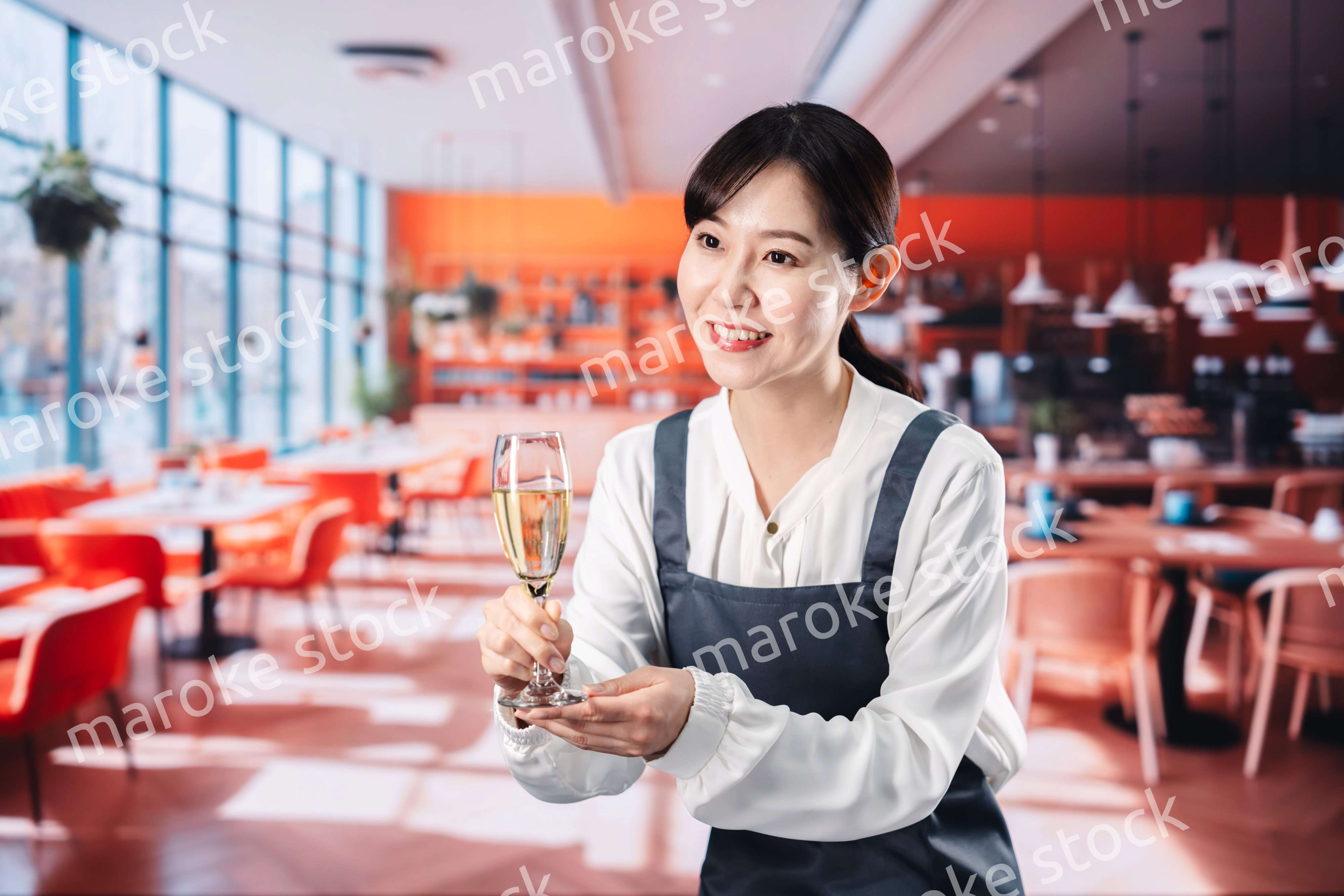 レストランでスパークリングワインを提供する女性