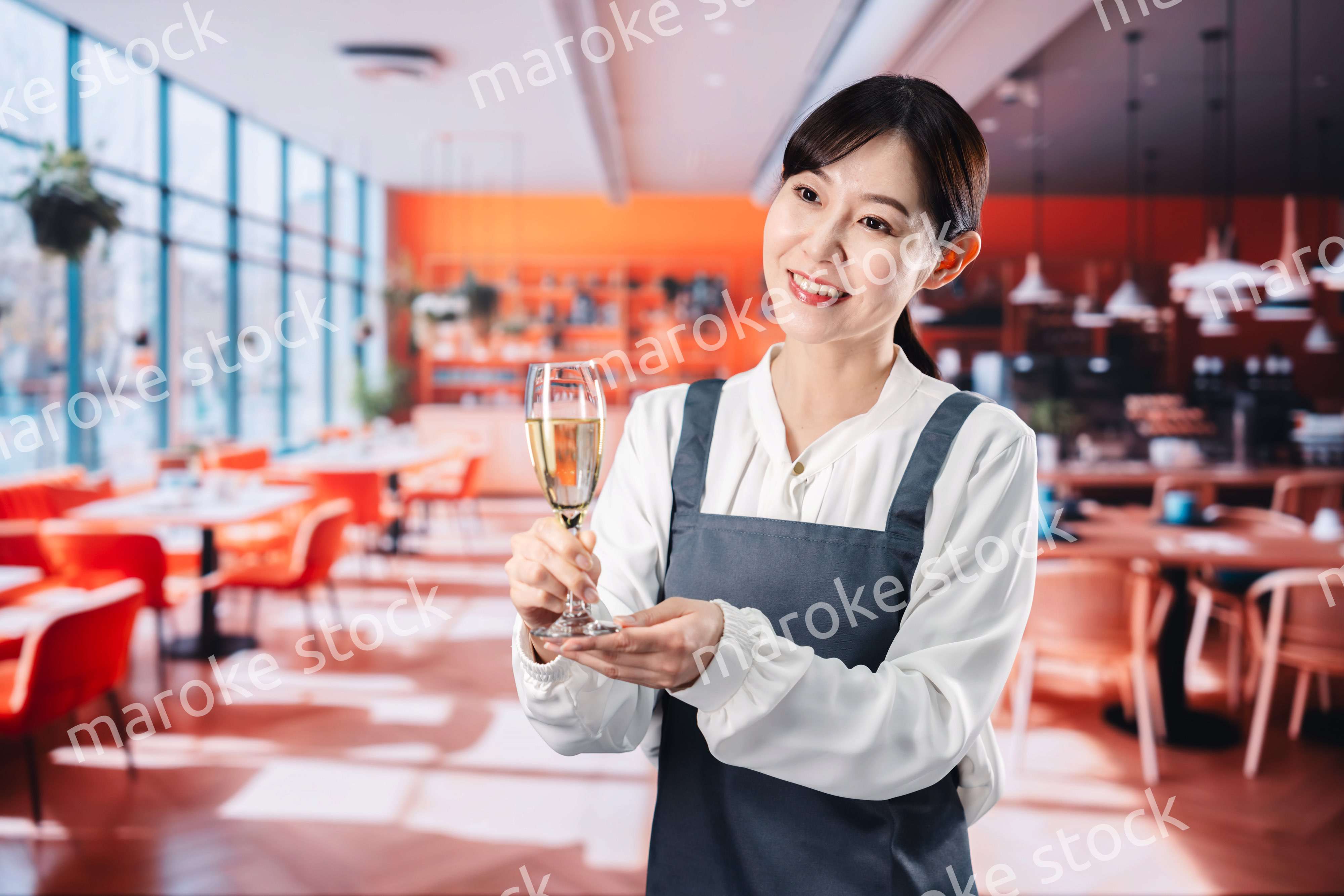 レストランでスパークリングワインを提供する女性