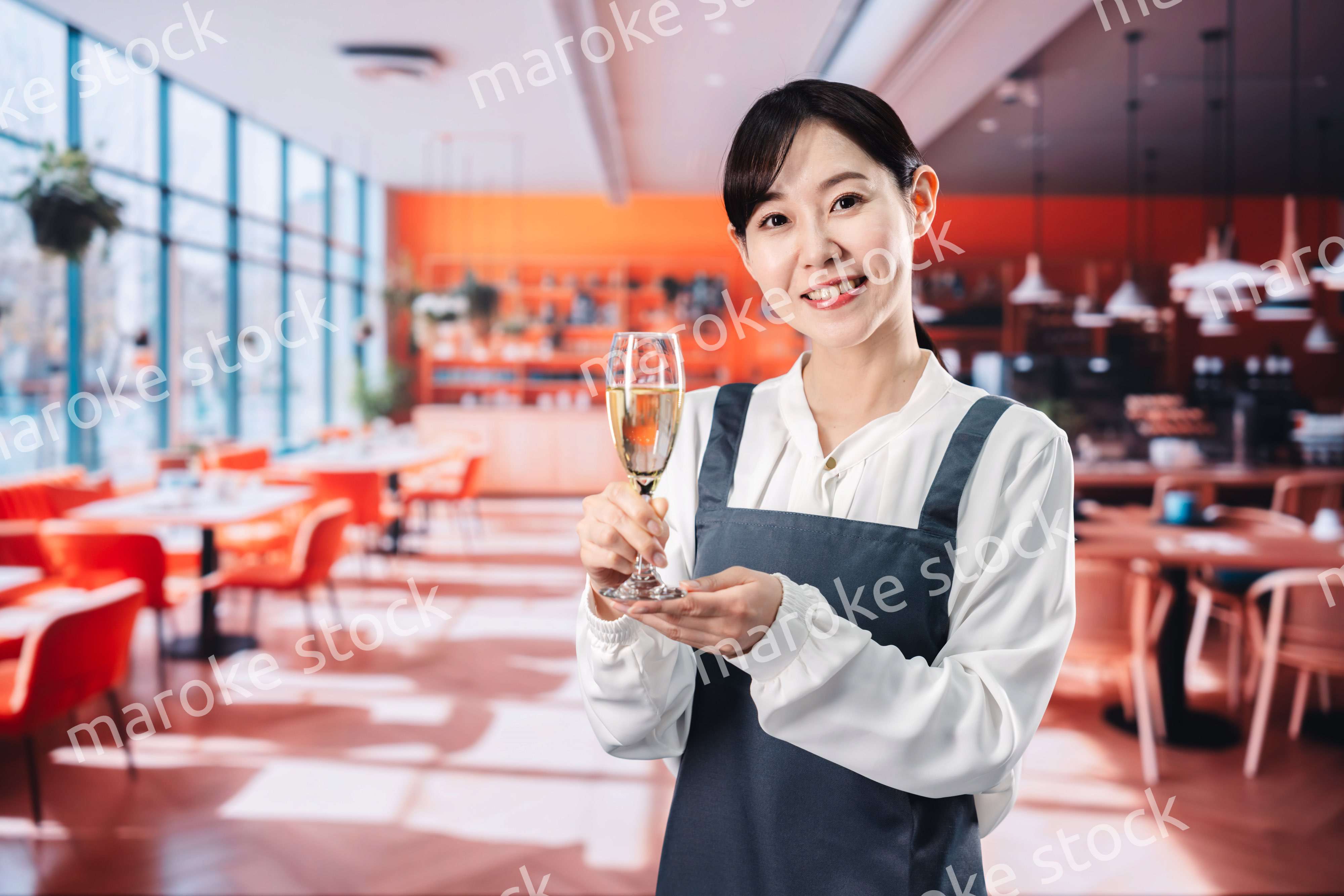 レストランでスパークリングワインを提供する女性