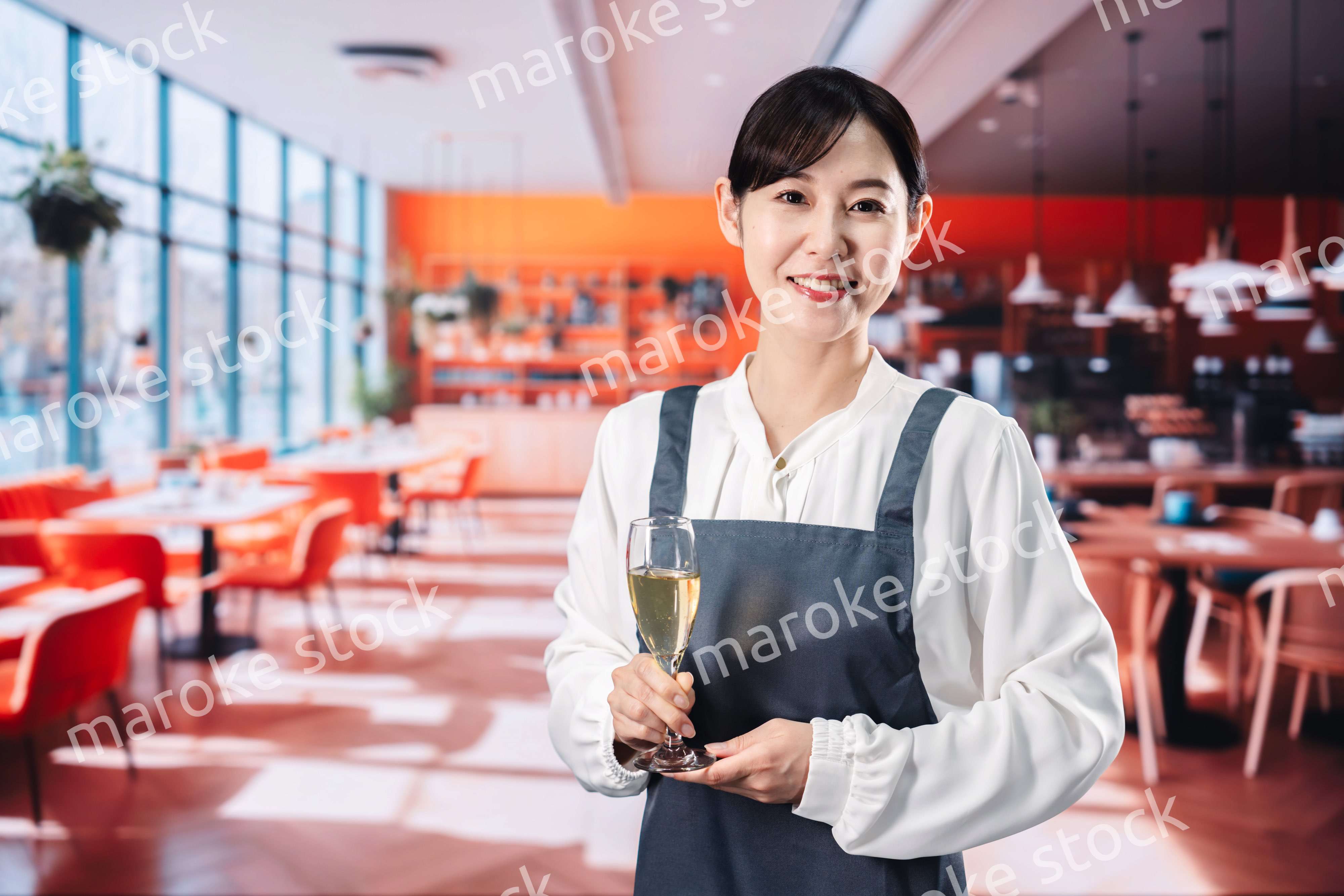 レストランでスパークリングワインを提供する女性