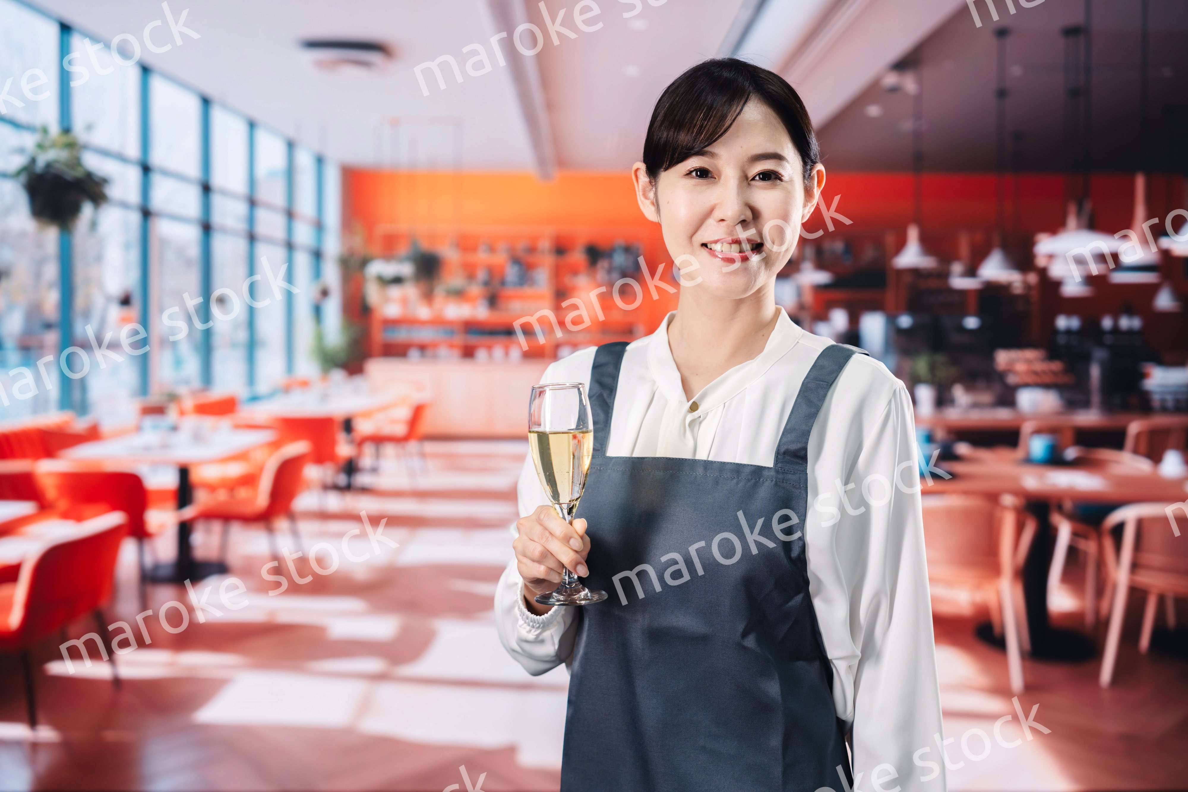 レストランでスパークリングワインを提供する女性
