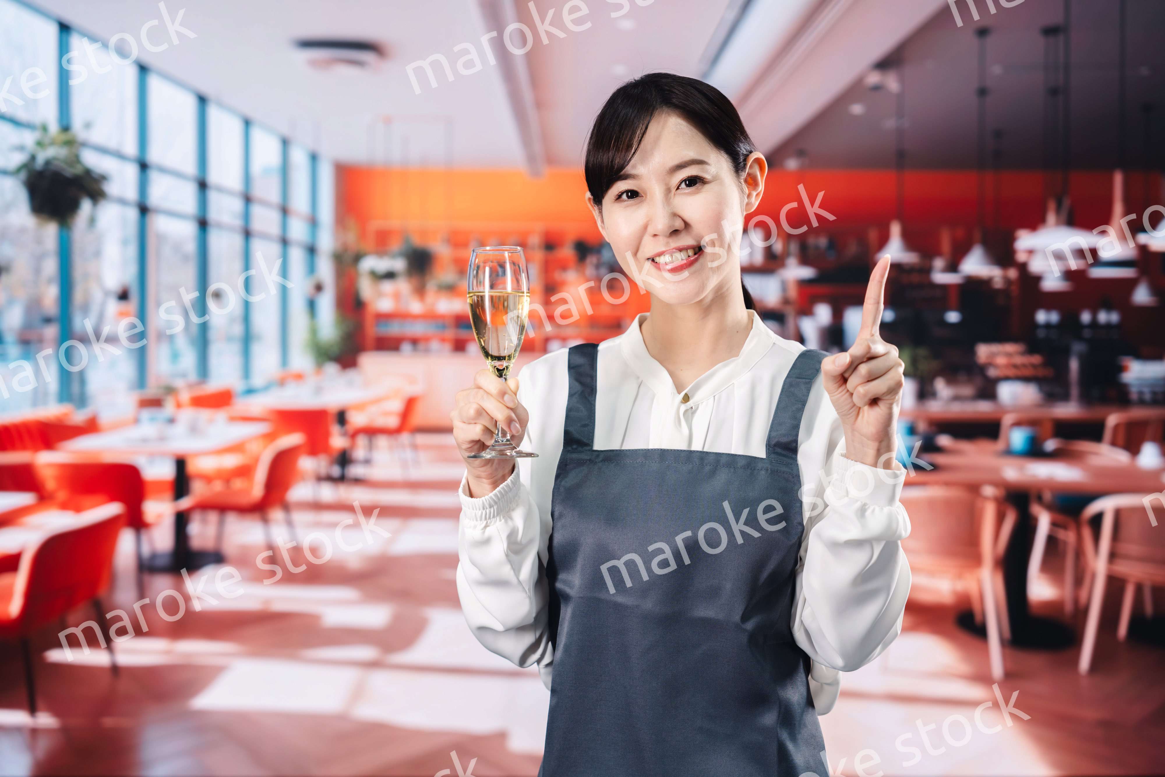 レストランでスパークリングワインを提供する女性