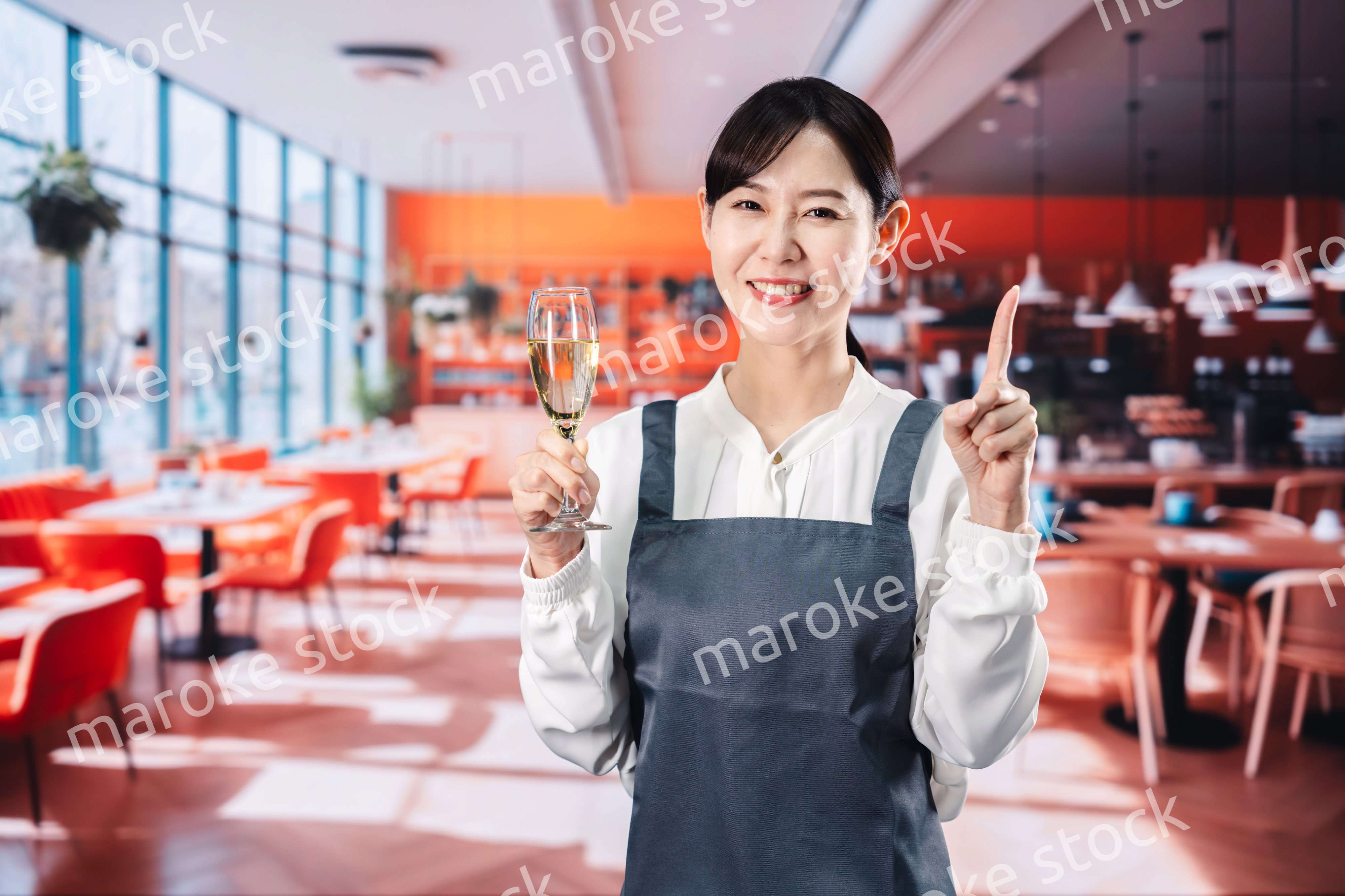 レストランでスパークリングワインを提供する女性