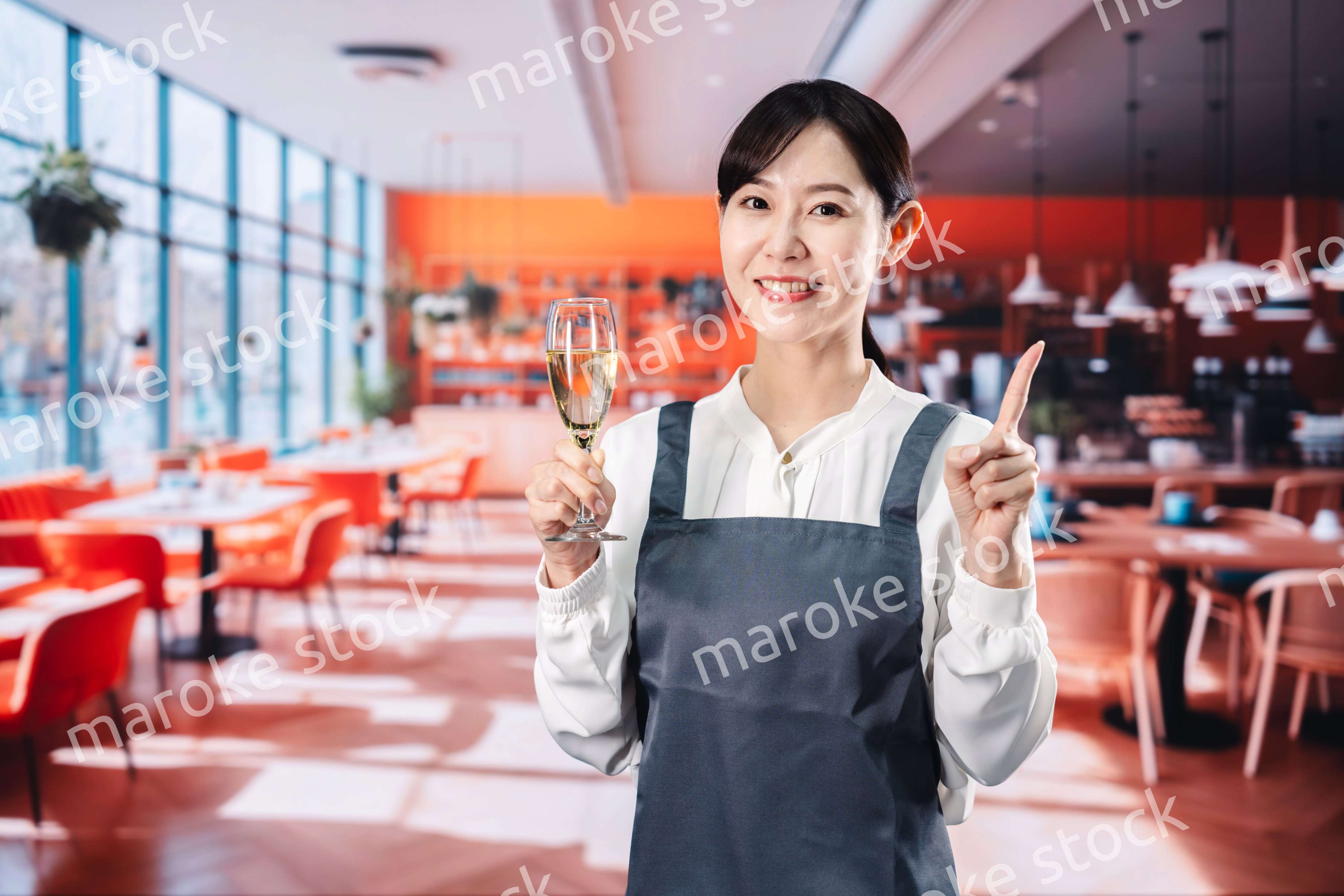 レストランでスパークリングワインを提供する女性