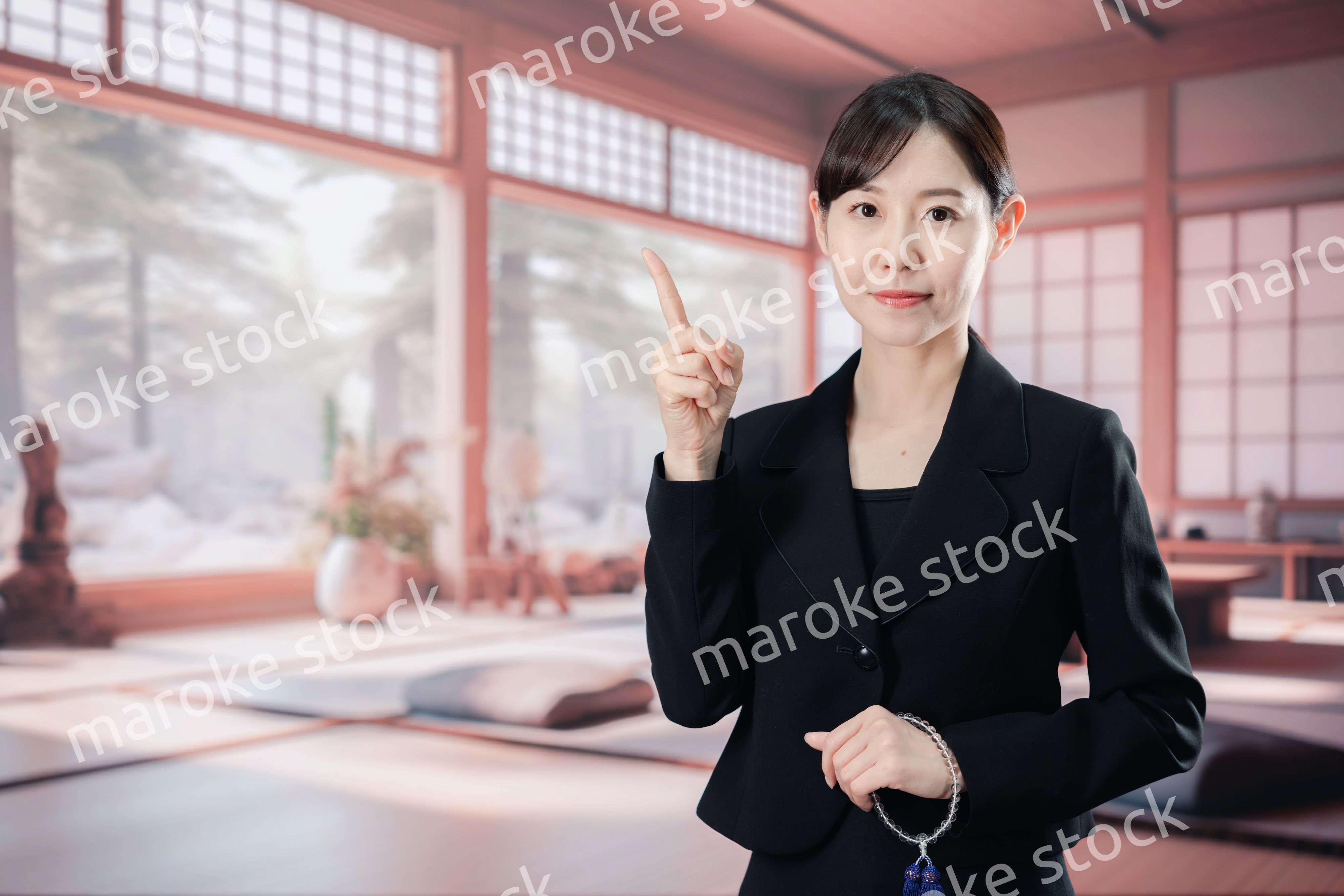 喪服で指を指しアドバイスをする女性