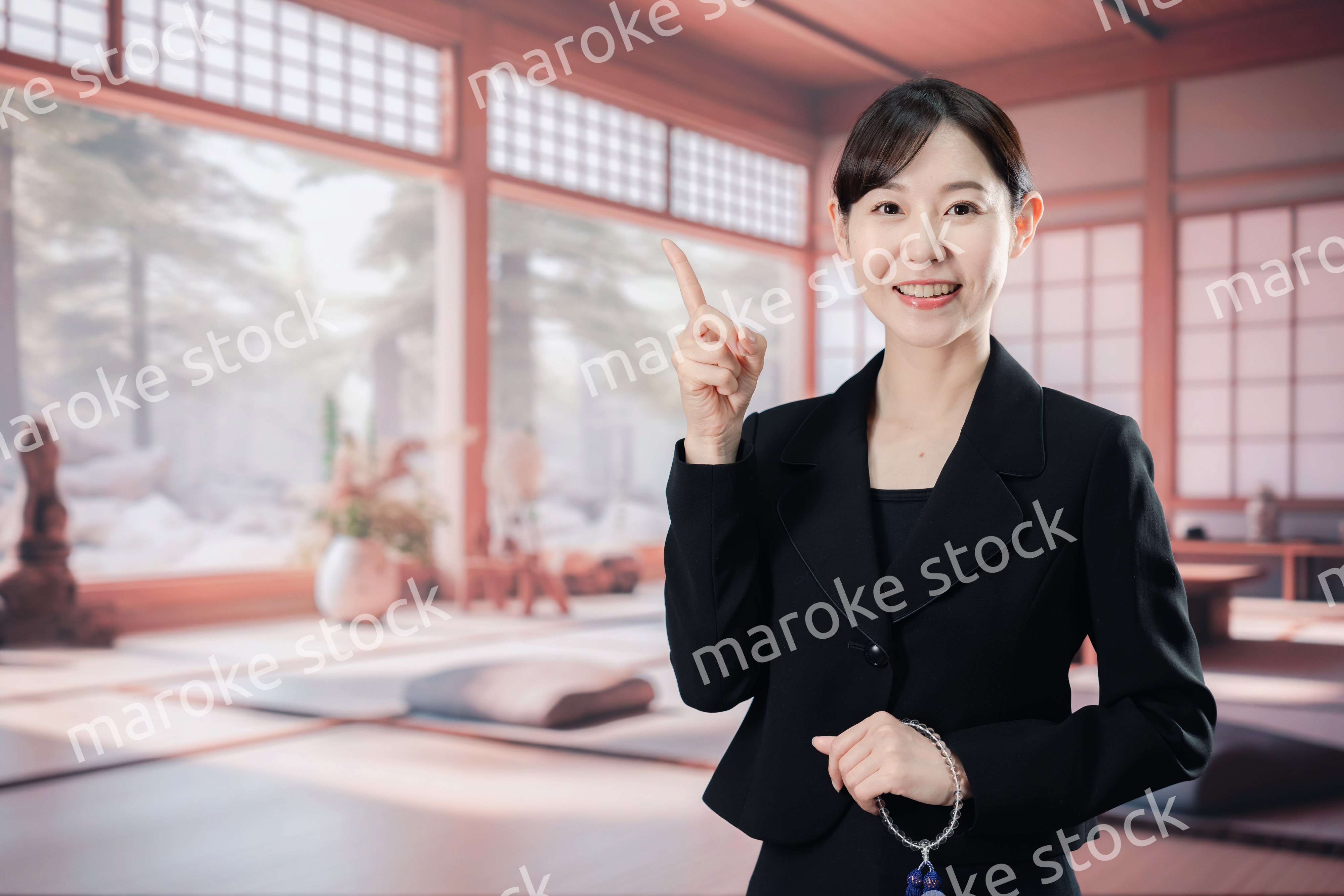 喪服で指を指しアドバイスをする女性