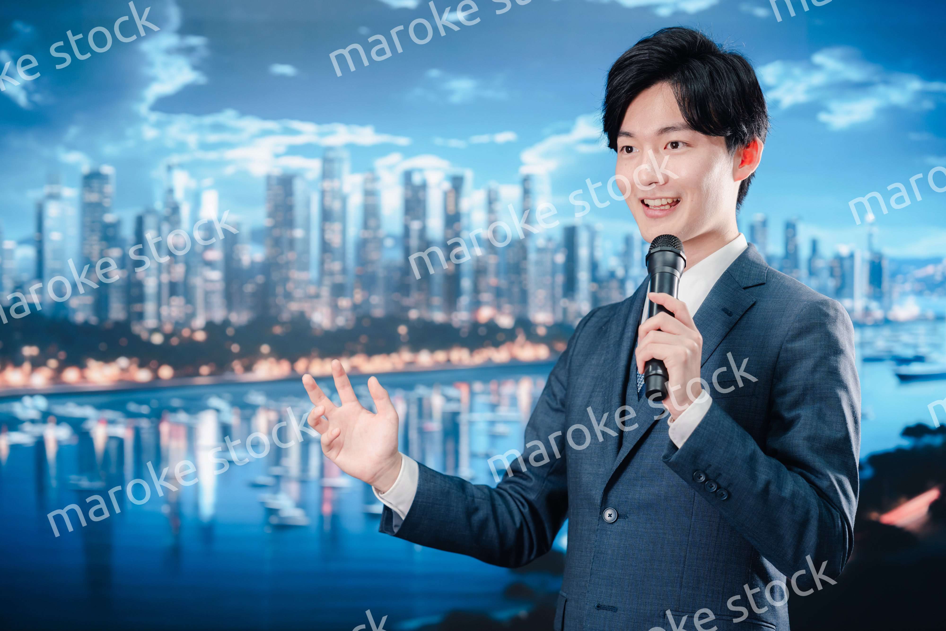 野外でマイクを使って話すスーツを着た男性