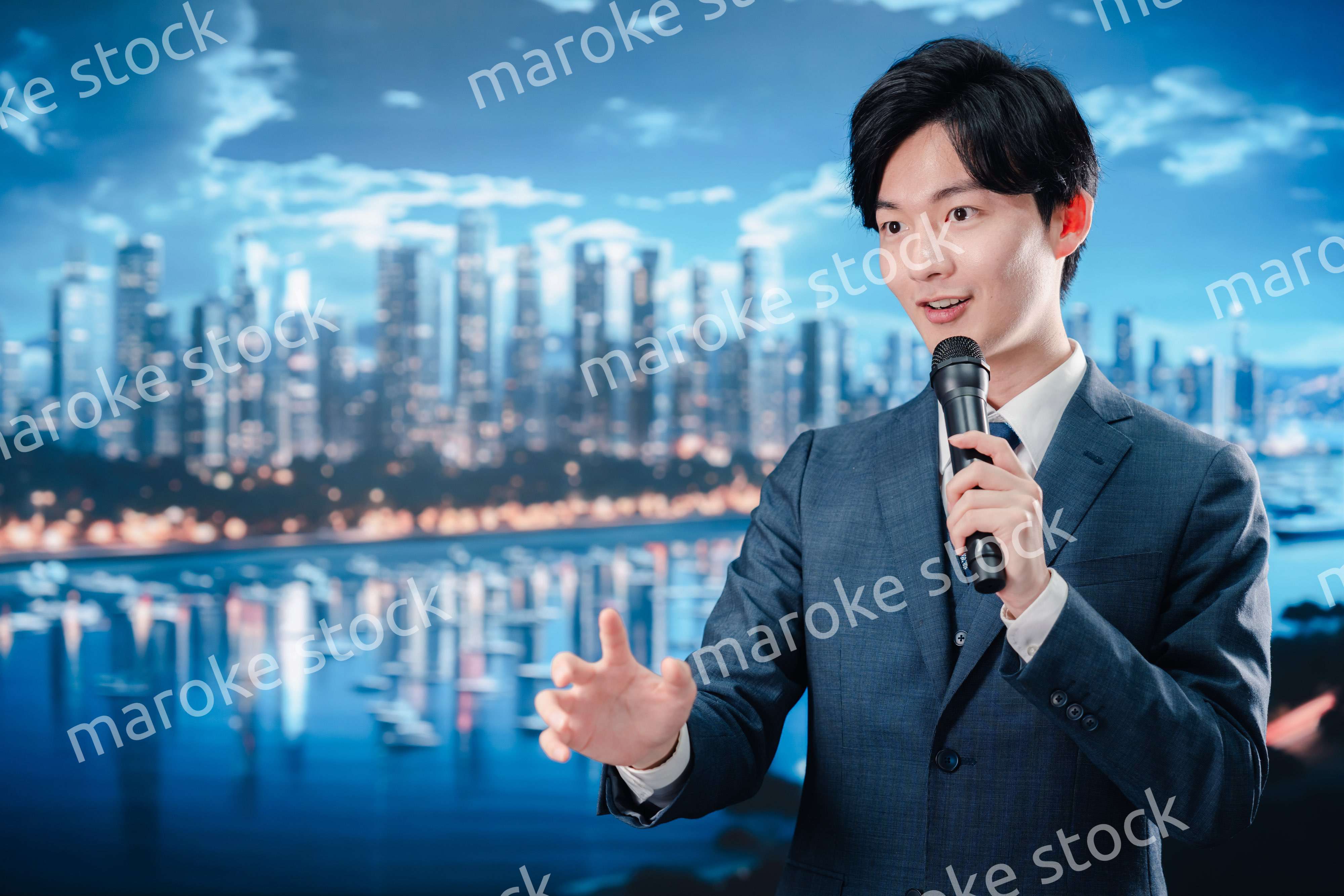 野外でマイクを使って話すスーツを着た男性