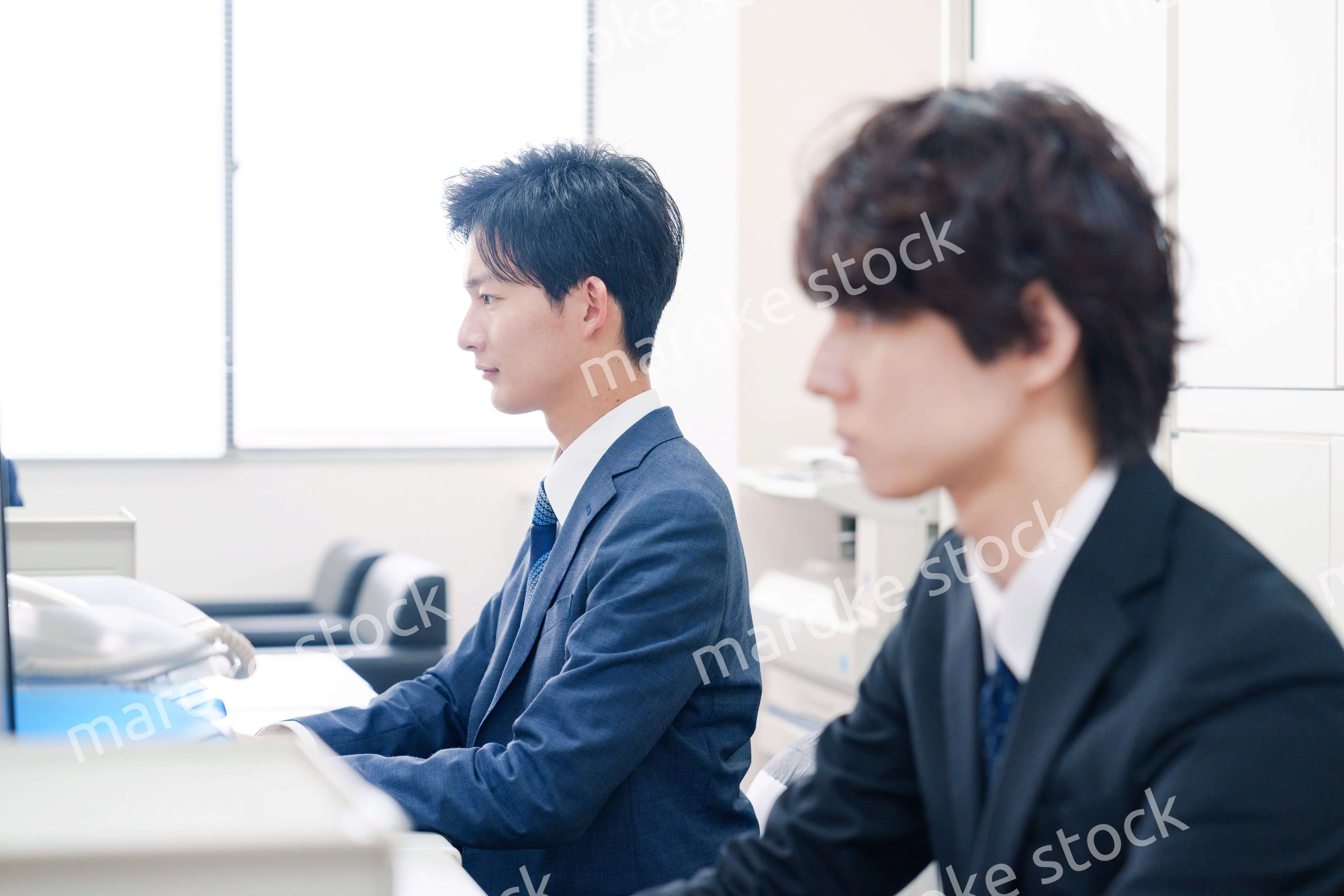 オフィスで集中してデスクワークをするビジネスマン