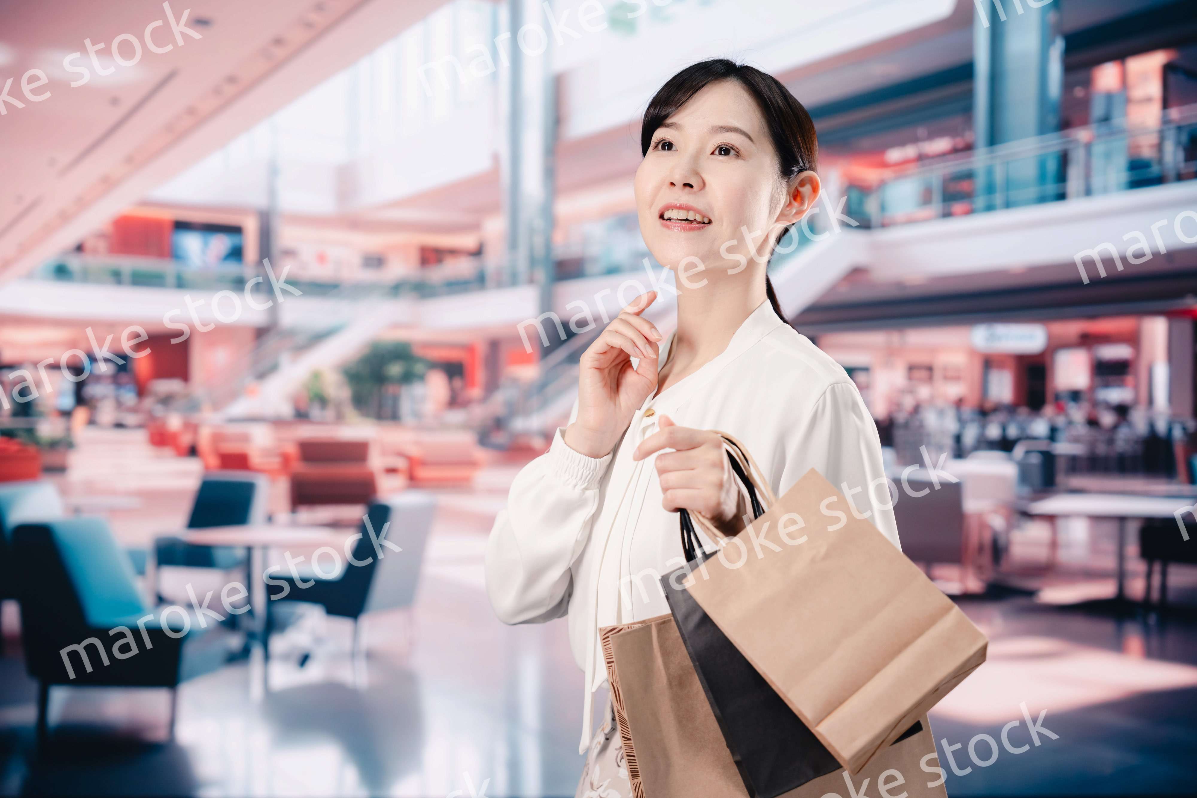 ショッピングモールで福袋を購入する若い女性