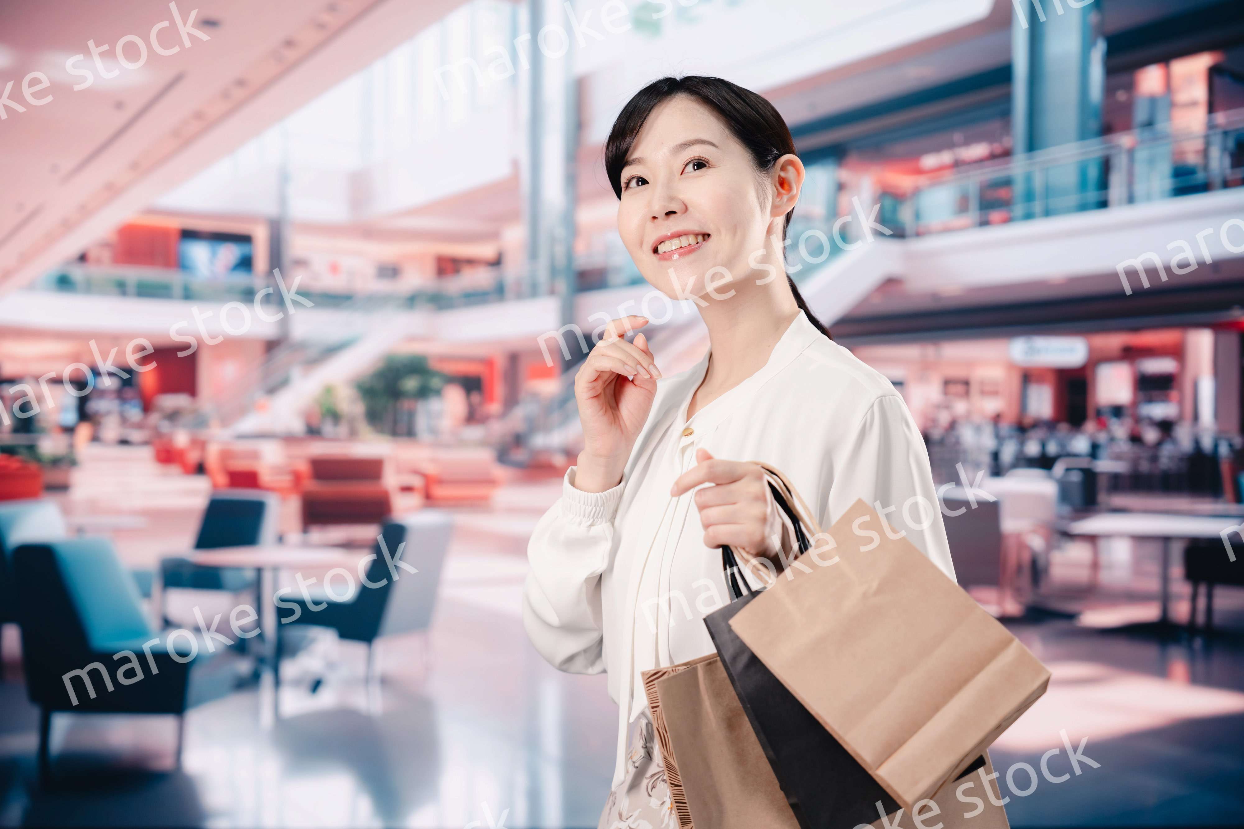 ショッピングモールで福袋を購入する若い女性