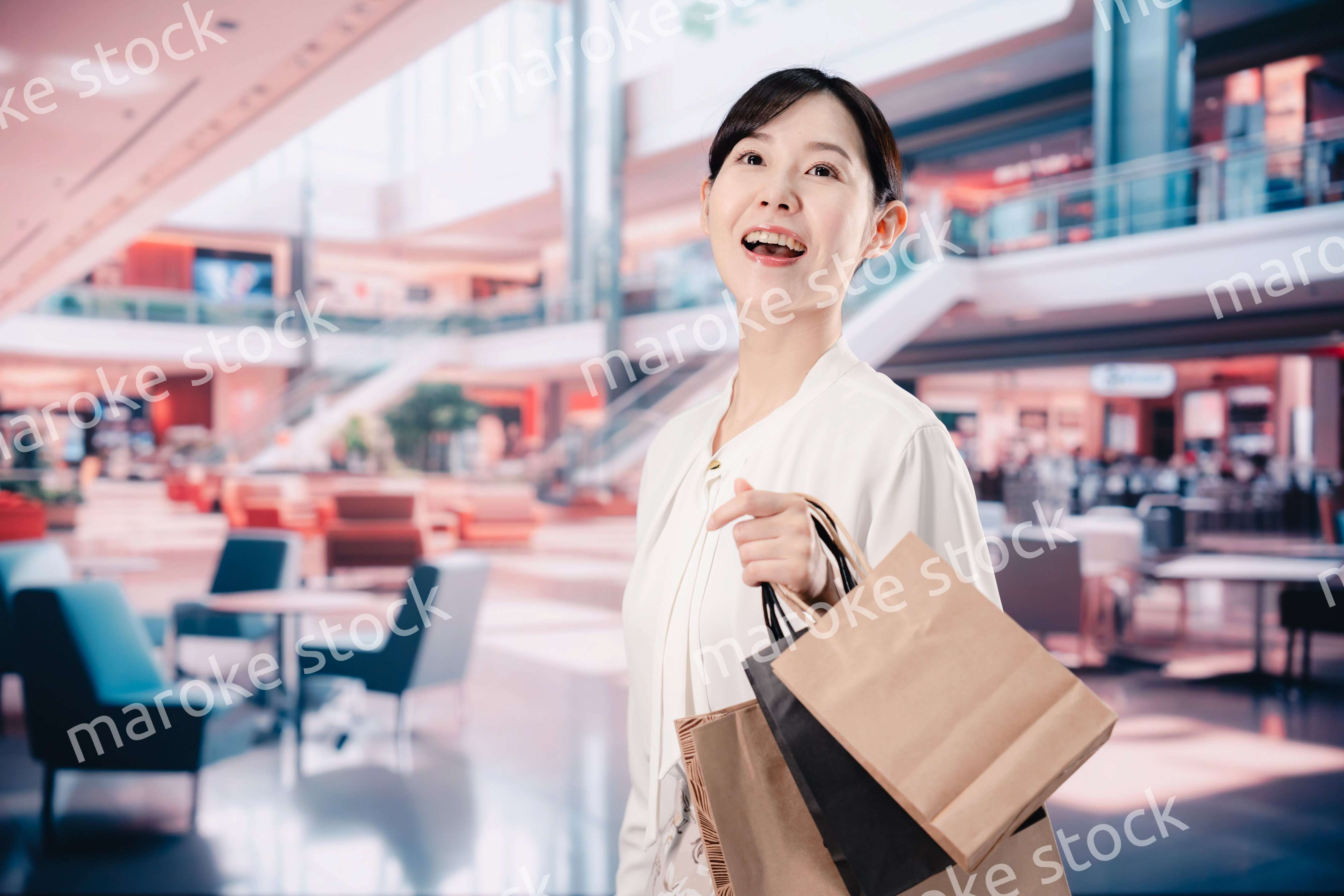 ショッピングモールで福袋を購入する若い女性