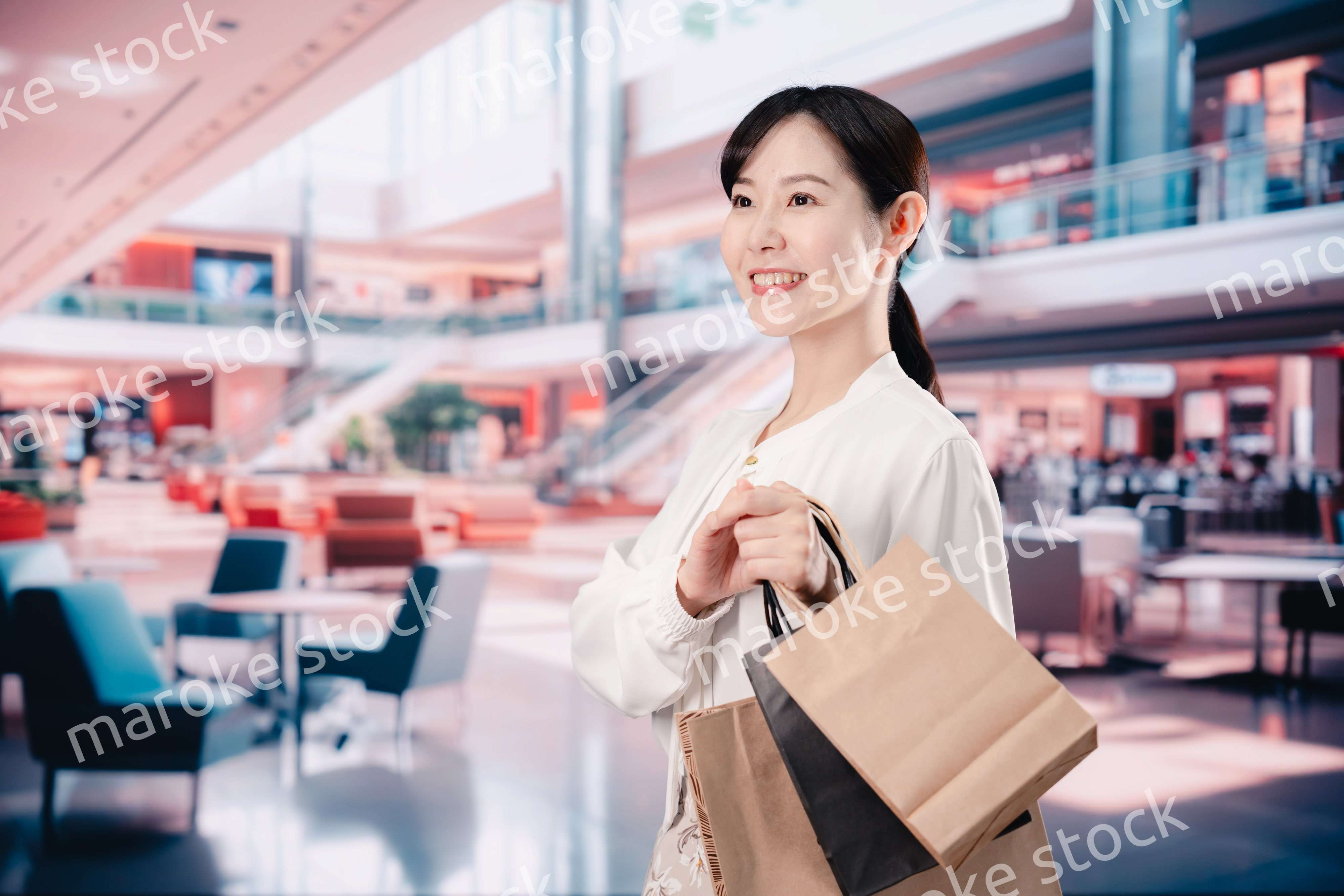 ショッピングモールで福袋を購入する若い女性