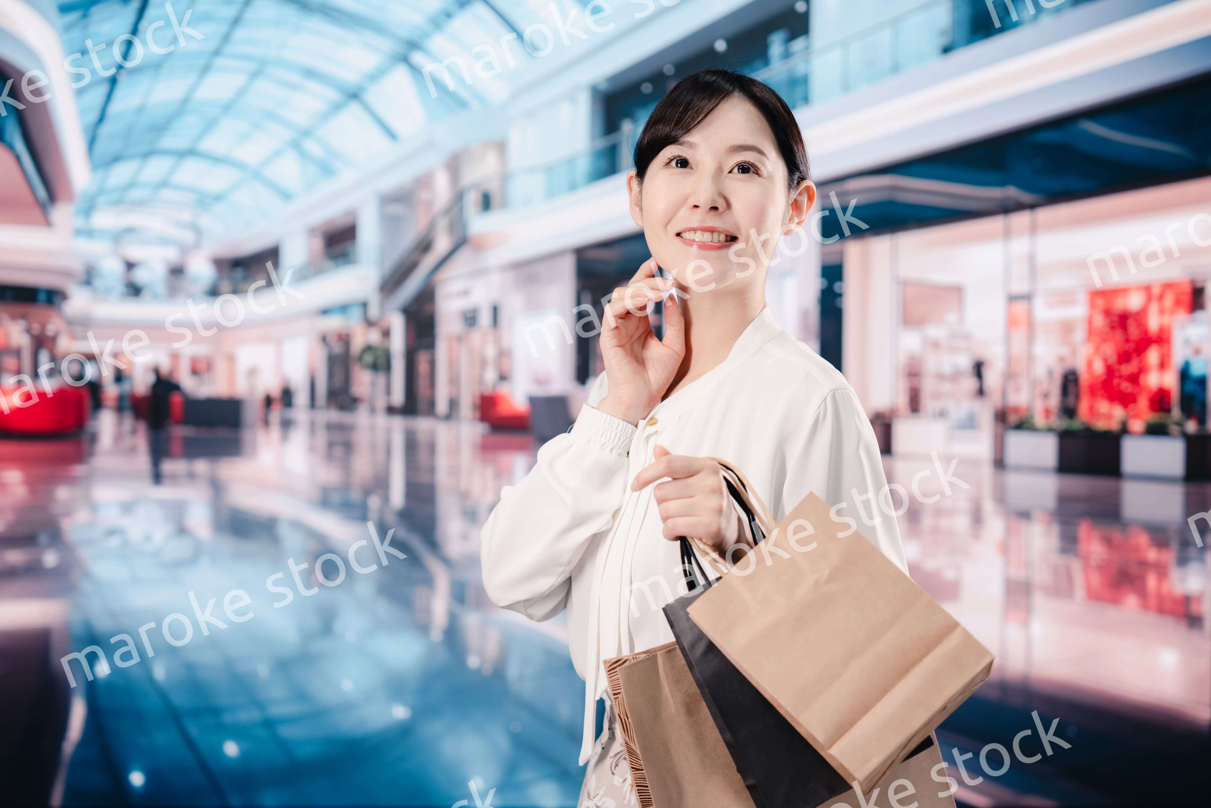 ショッピングモールで福袋を購入する若い女性