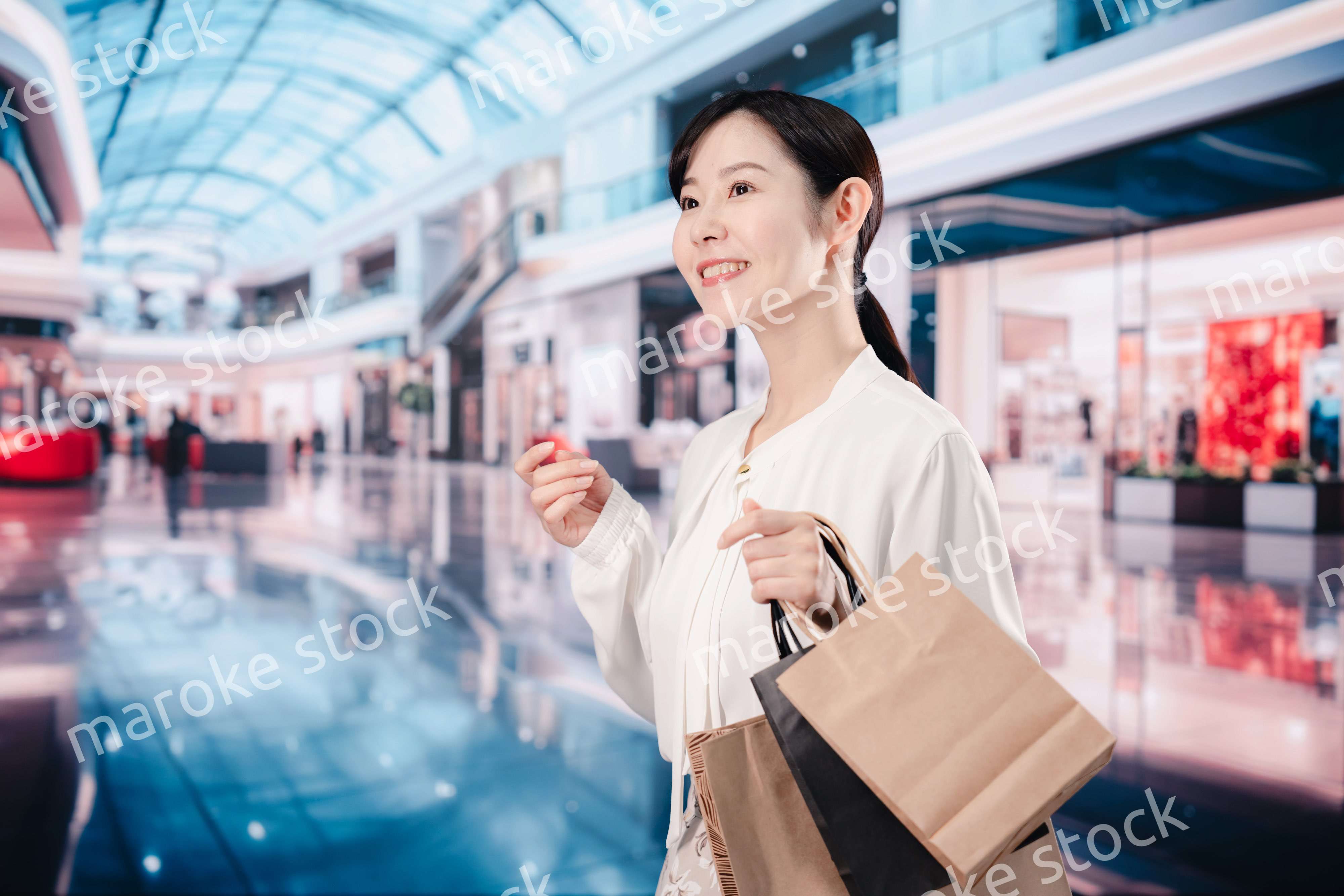 ショッピングモールで福袋を購入する若い女性