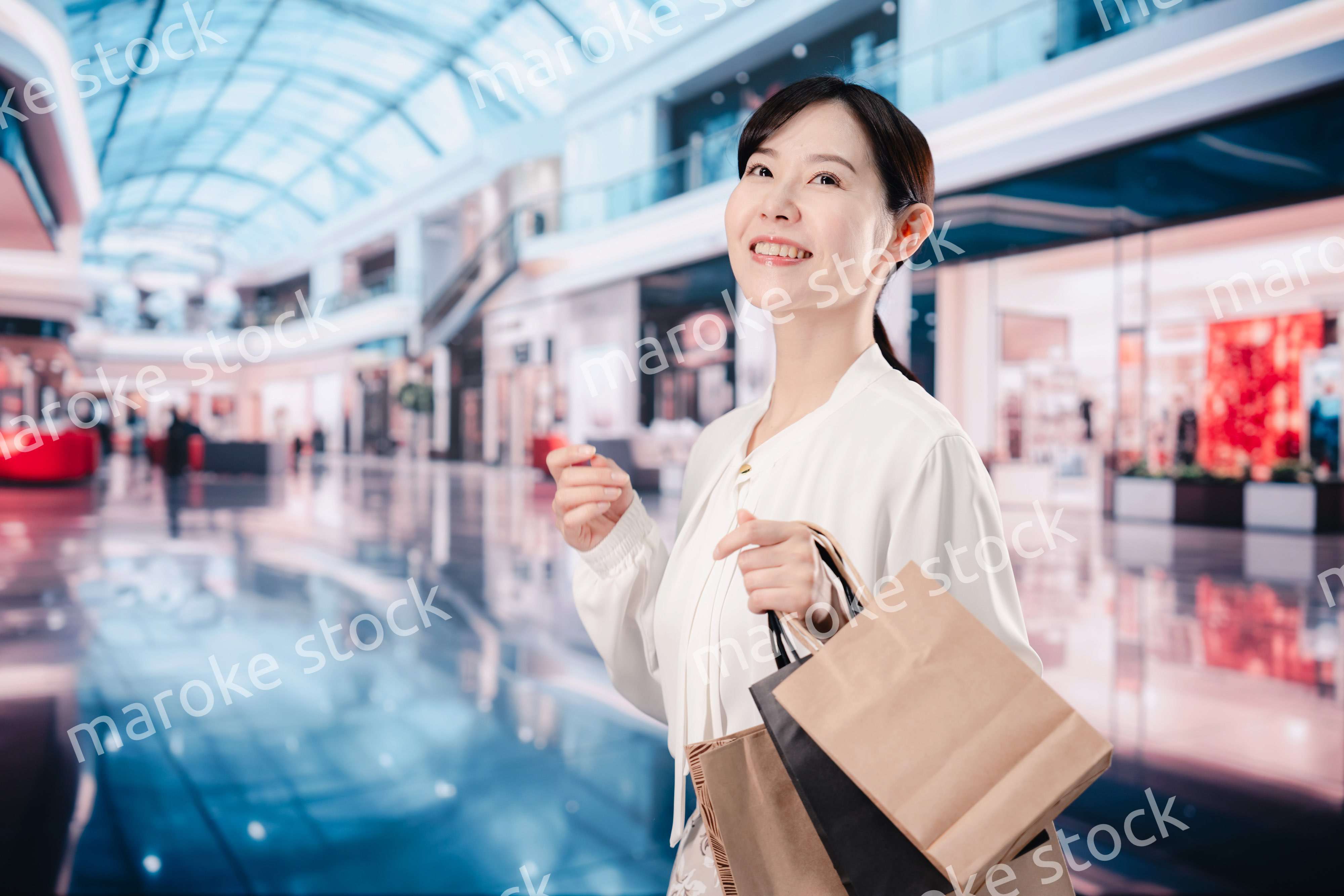 ショッピングモールで福袋を購入する若い女性