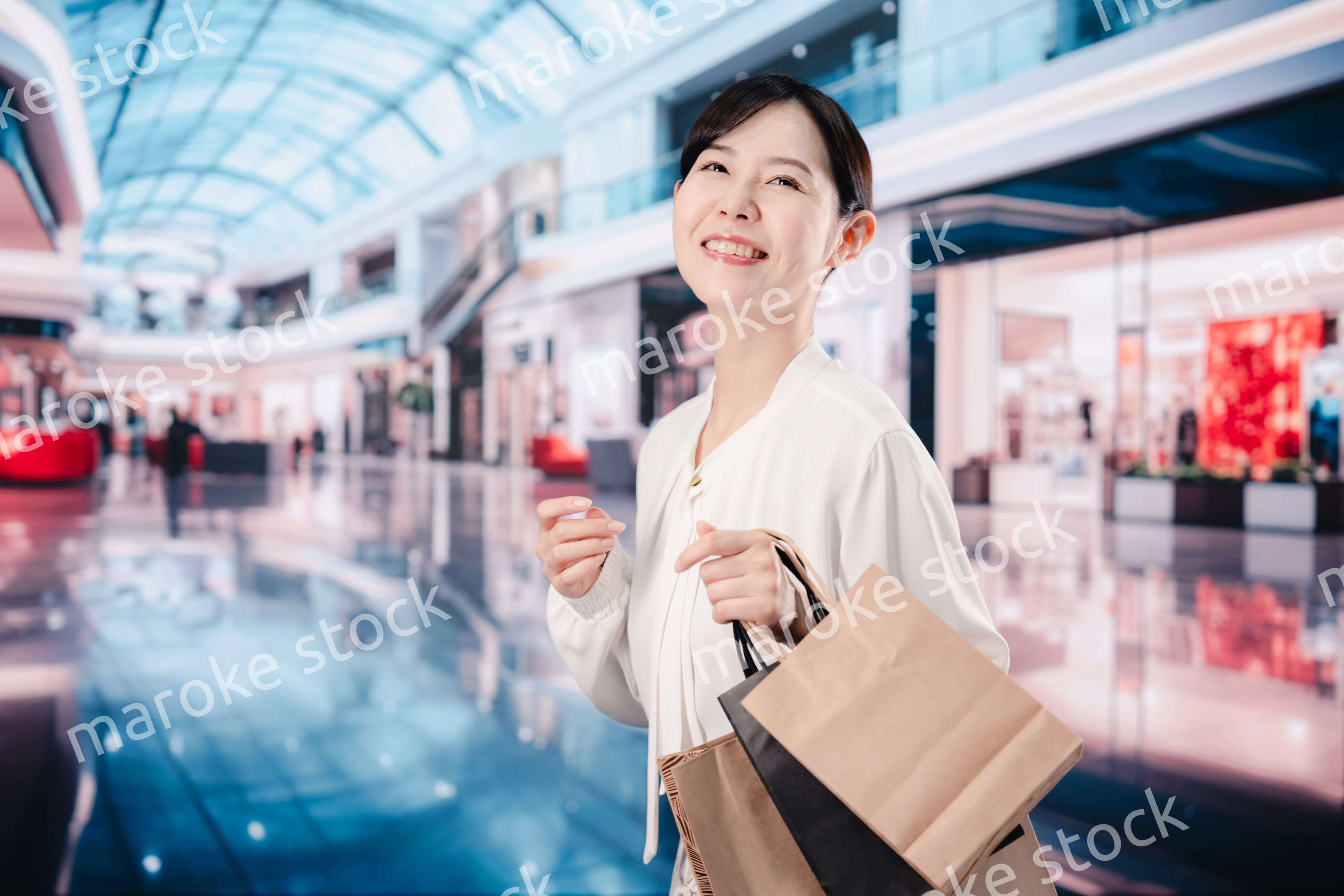 ショッピングモールで福袋を購入する若い女性