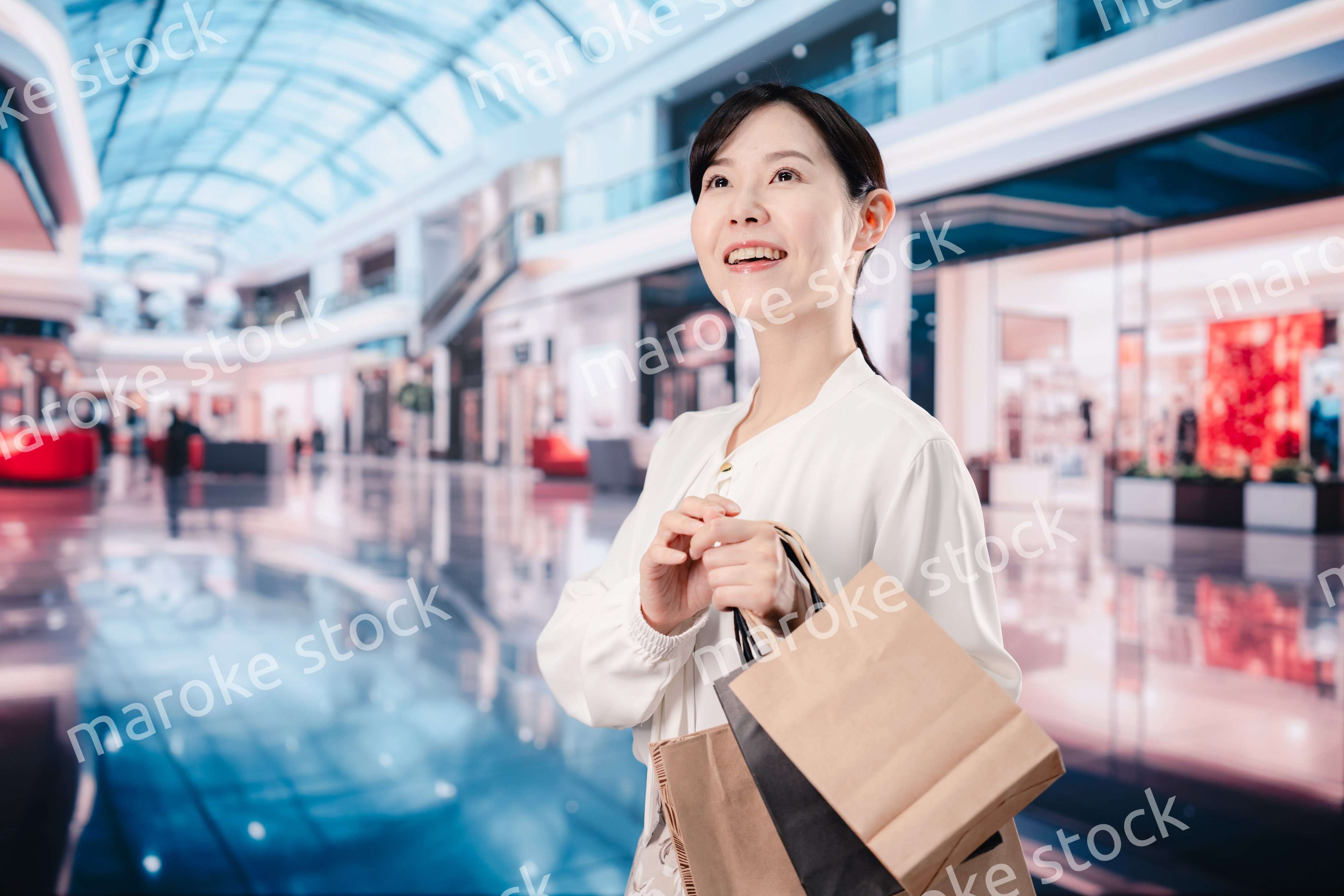 ショッピングモールで福袋を購入する若い女性