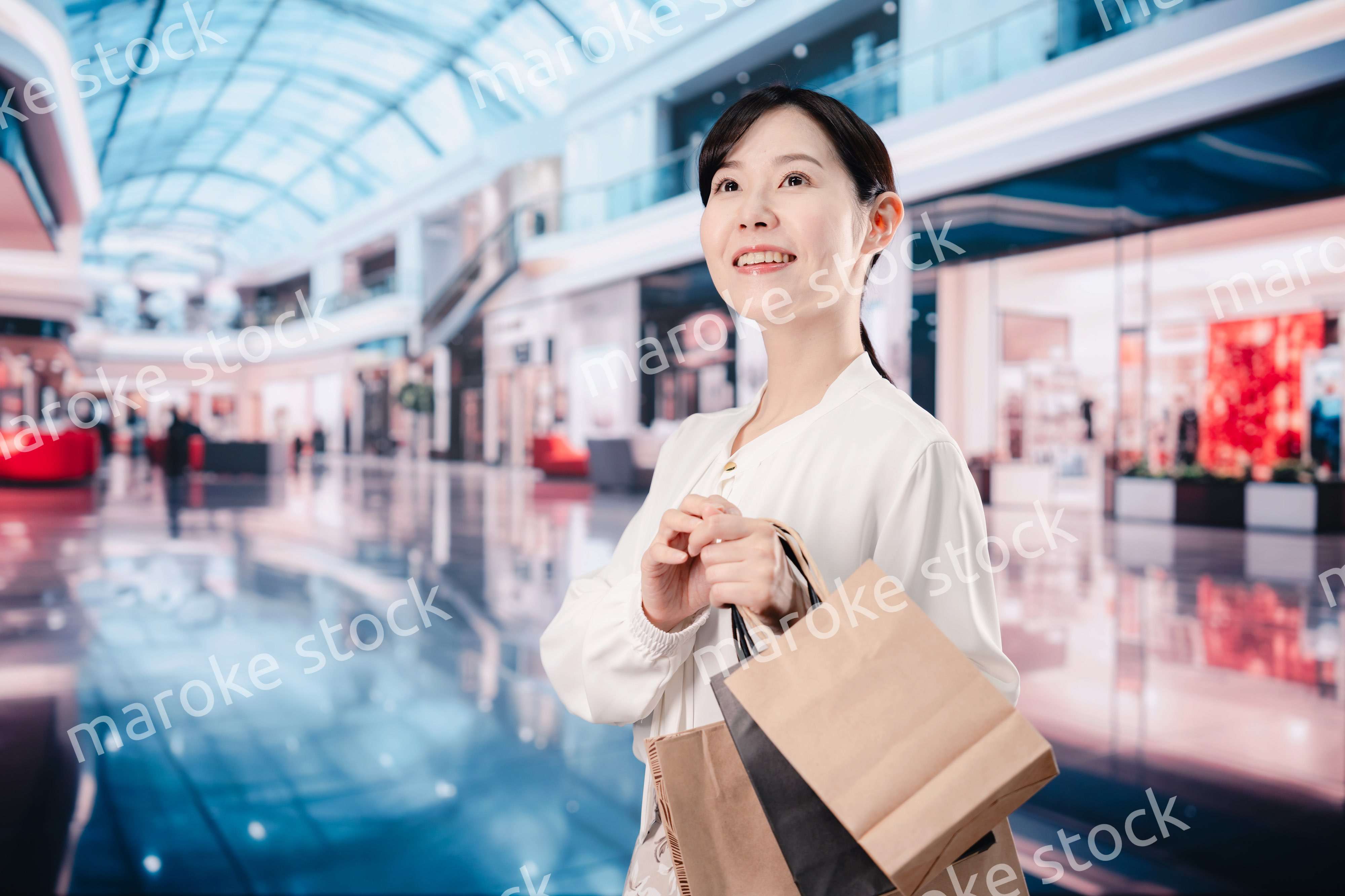 ショッピングモールで福袋を購入する若い女性