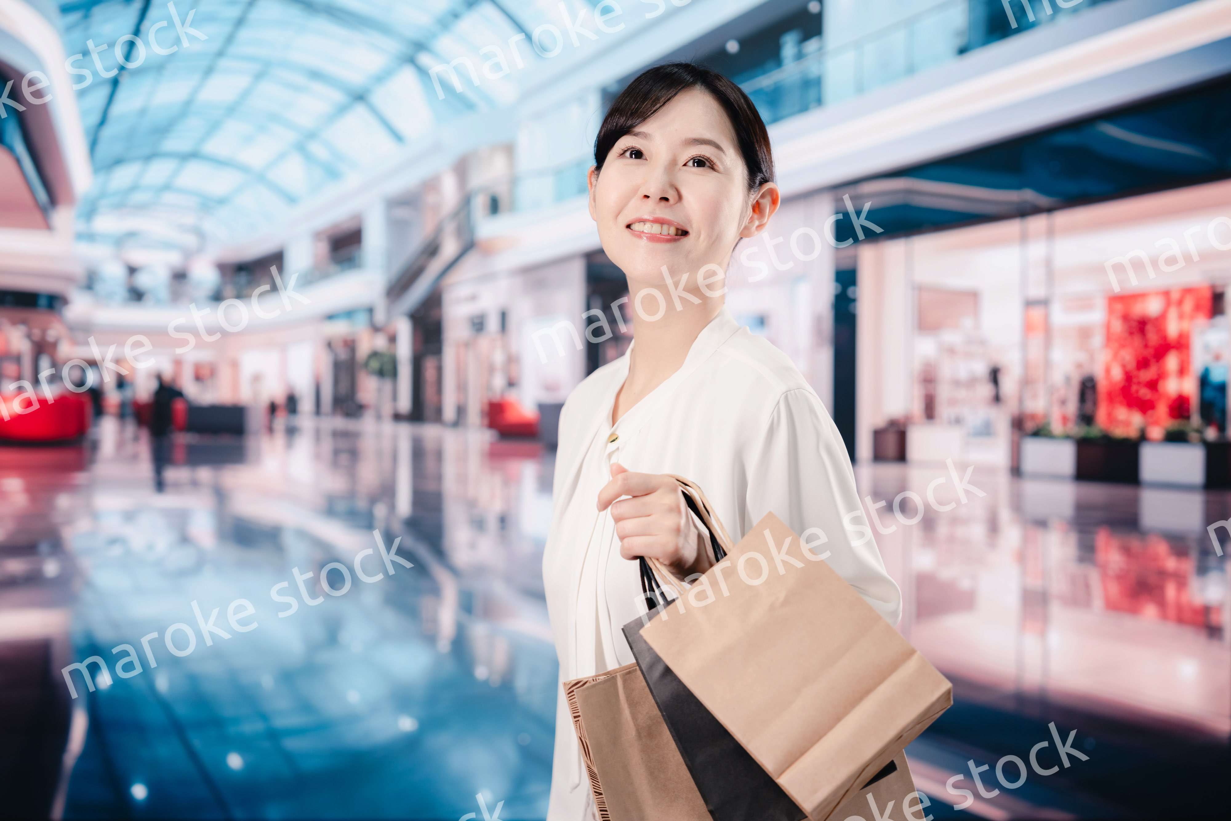 ショッピングモールで福袋を購入する若い女性