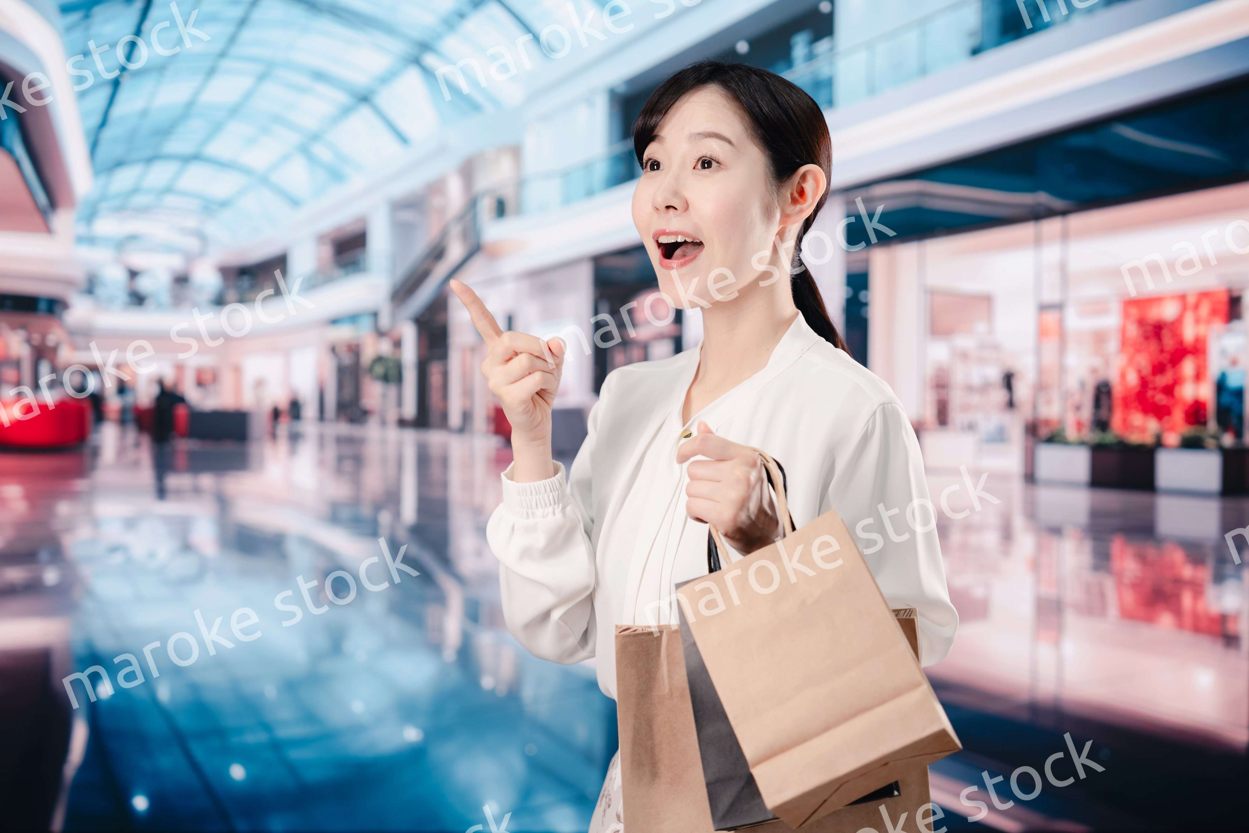 ショッピングモールで福袋を購入する若い女性