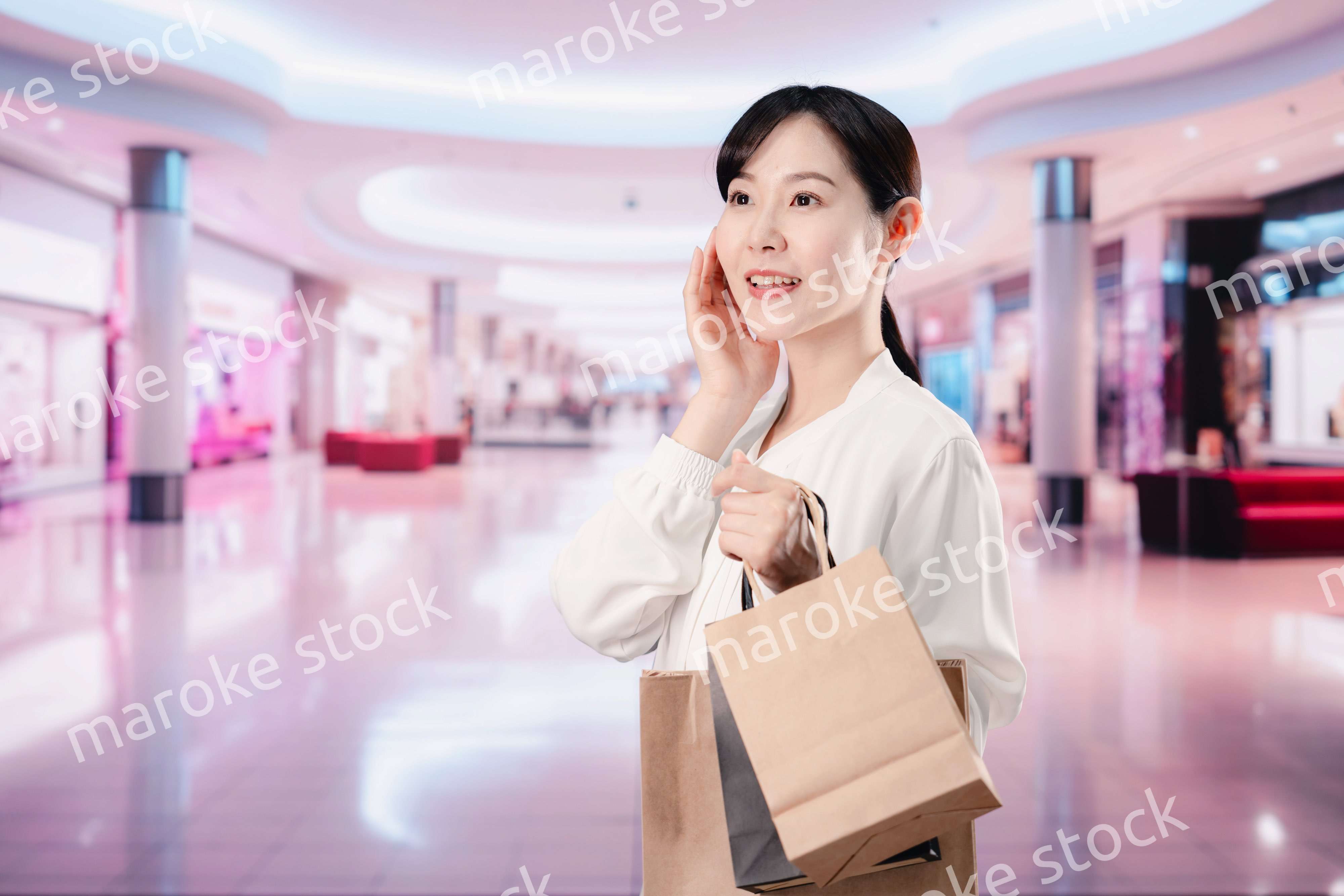 ショッピングモールで福袋を購入する若い女性