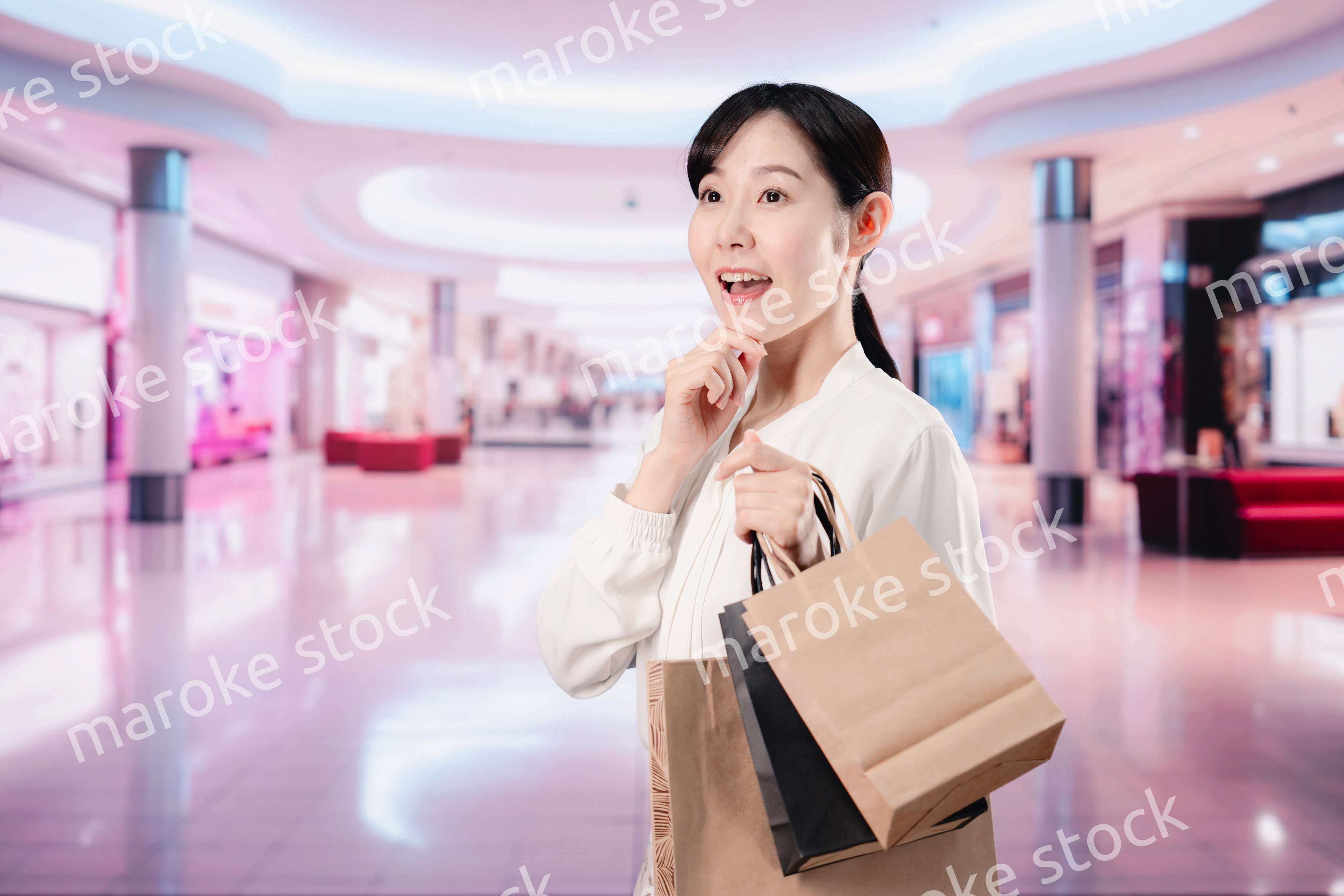 ショッピングモールで福袋を購入する若い女性