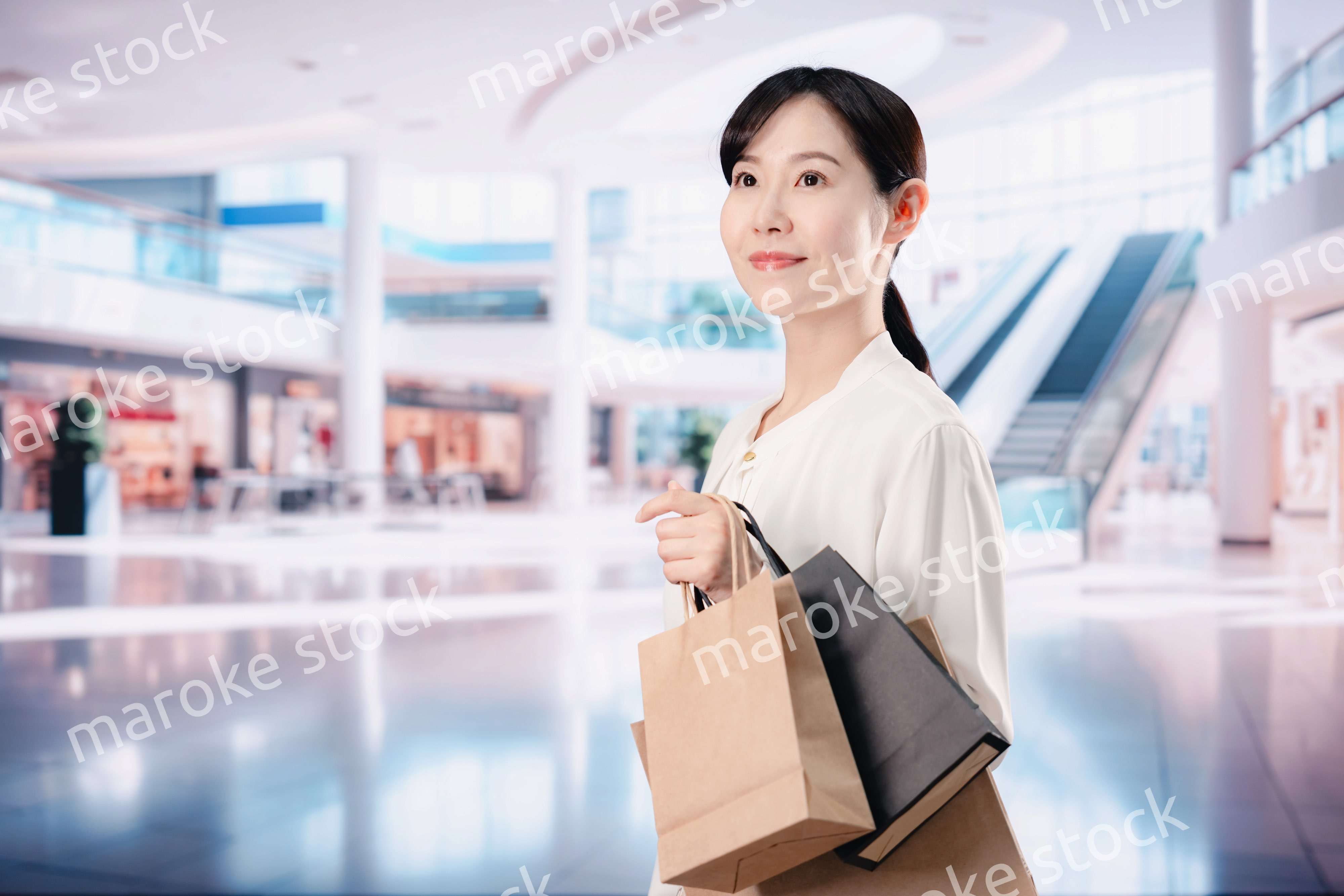 ショッピングモールで福袋を購入する若い女性