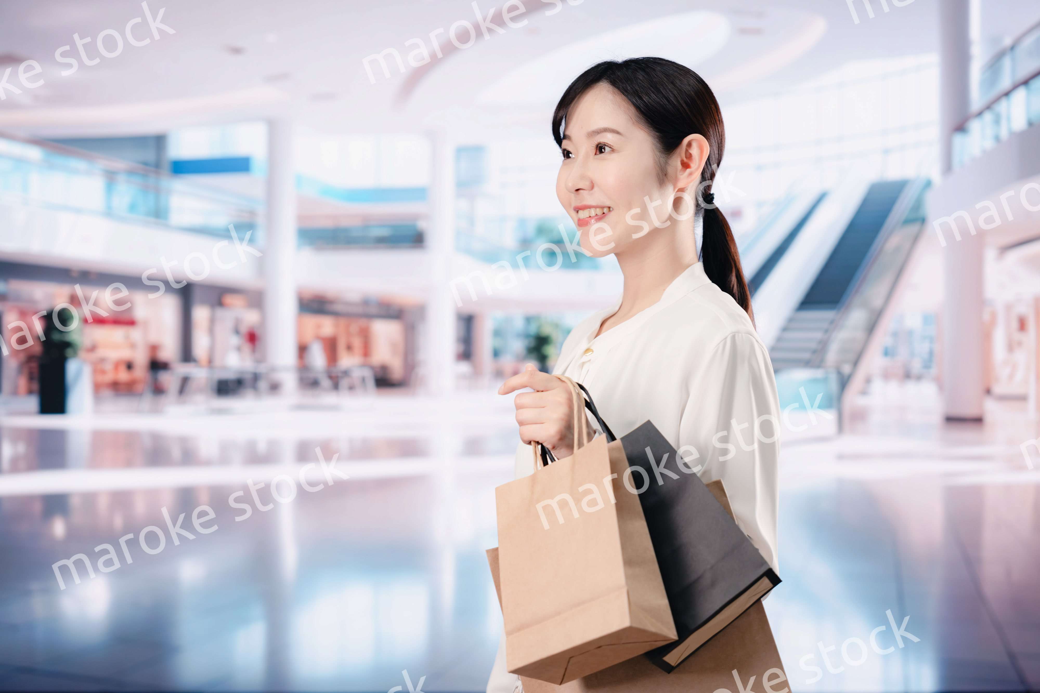 ショッピングモールで福袋を購入する若い女性