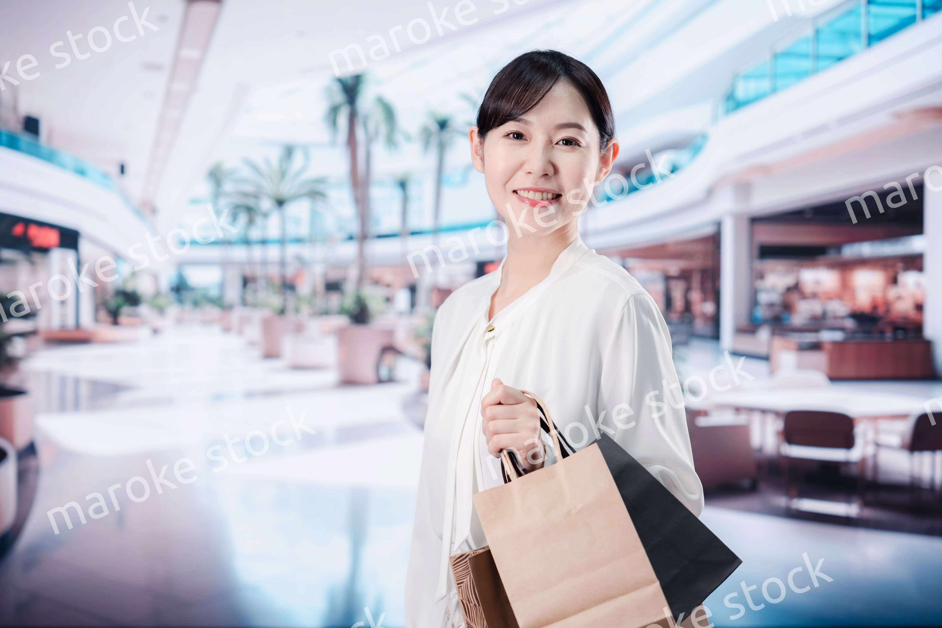 ショッピングモールで福袋を購入する若い女性