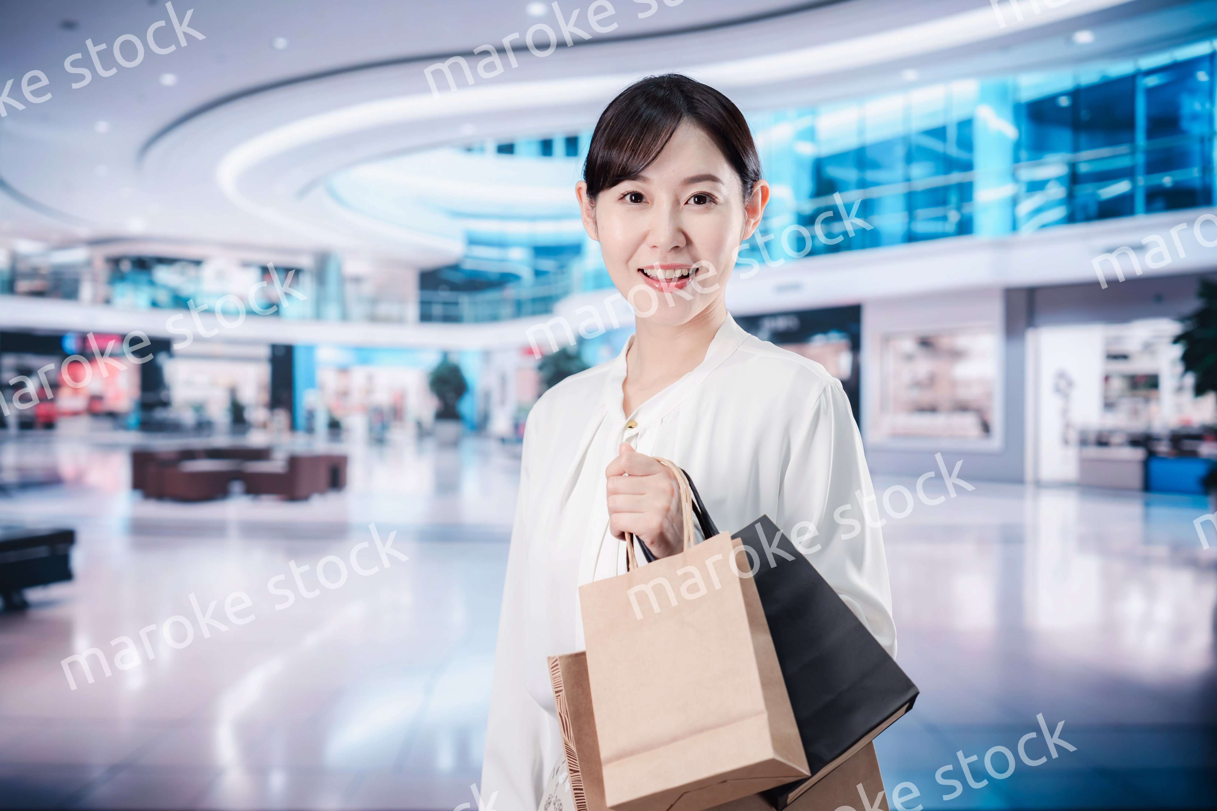 ショッピングモールで福袋を購入する若い女性