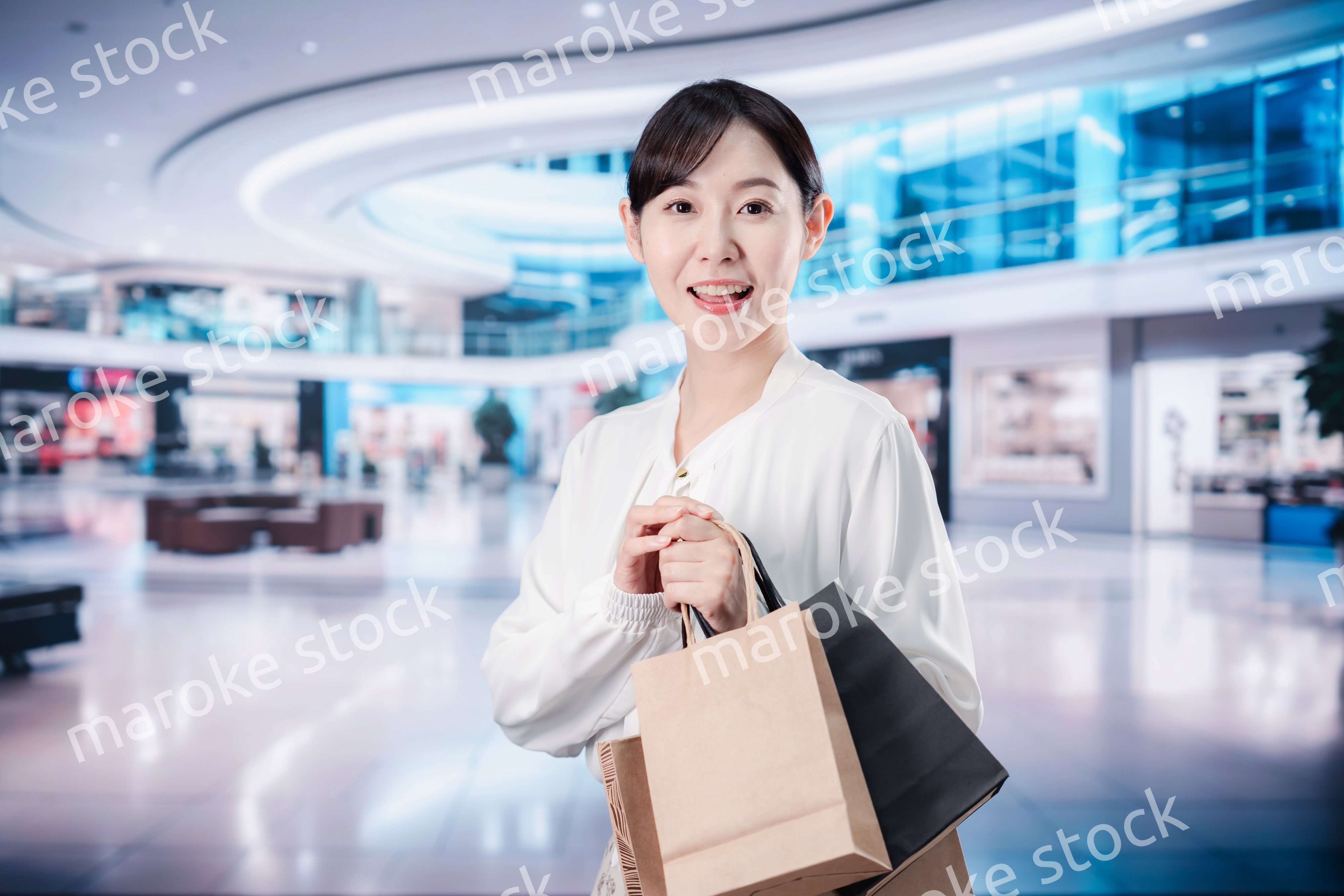 ショッピングモールで福袋を購入する若い女性