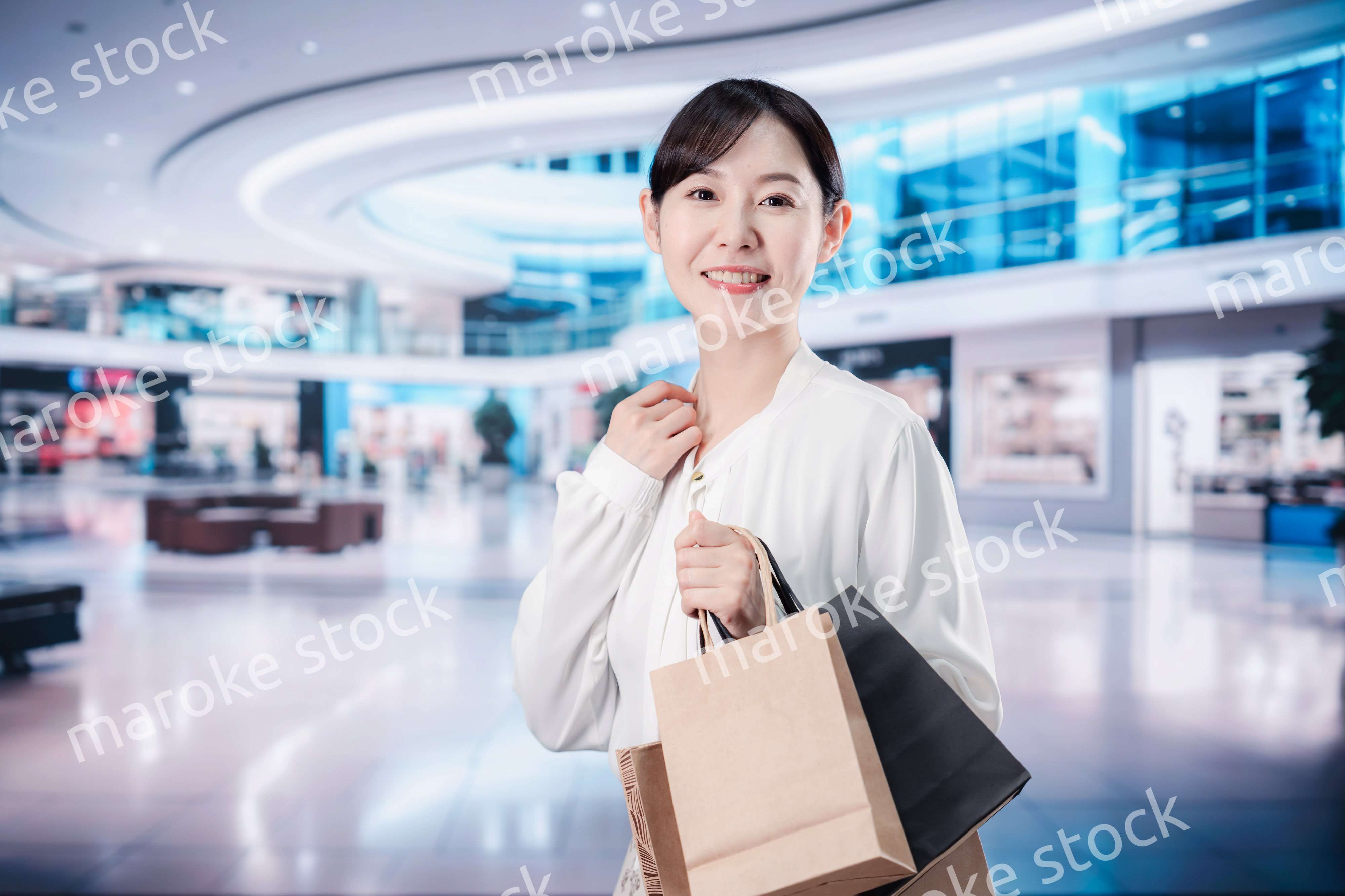 ショッピングモールで福袋を購入する若い女性