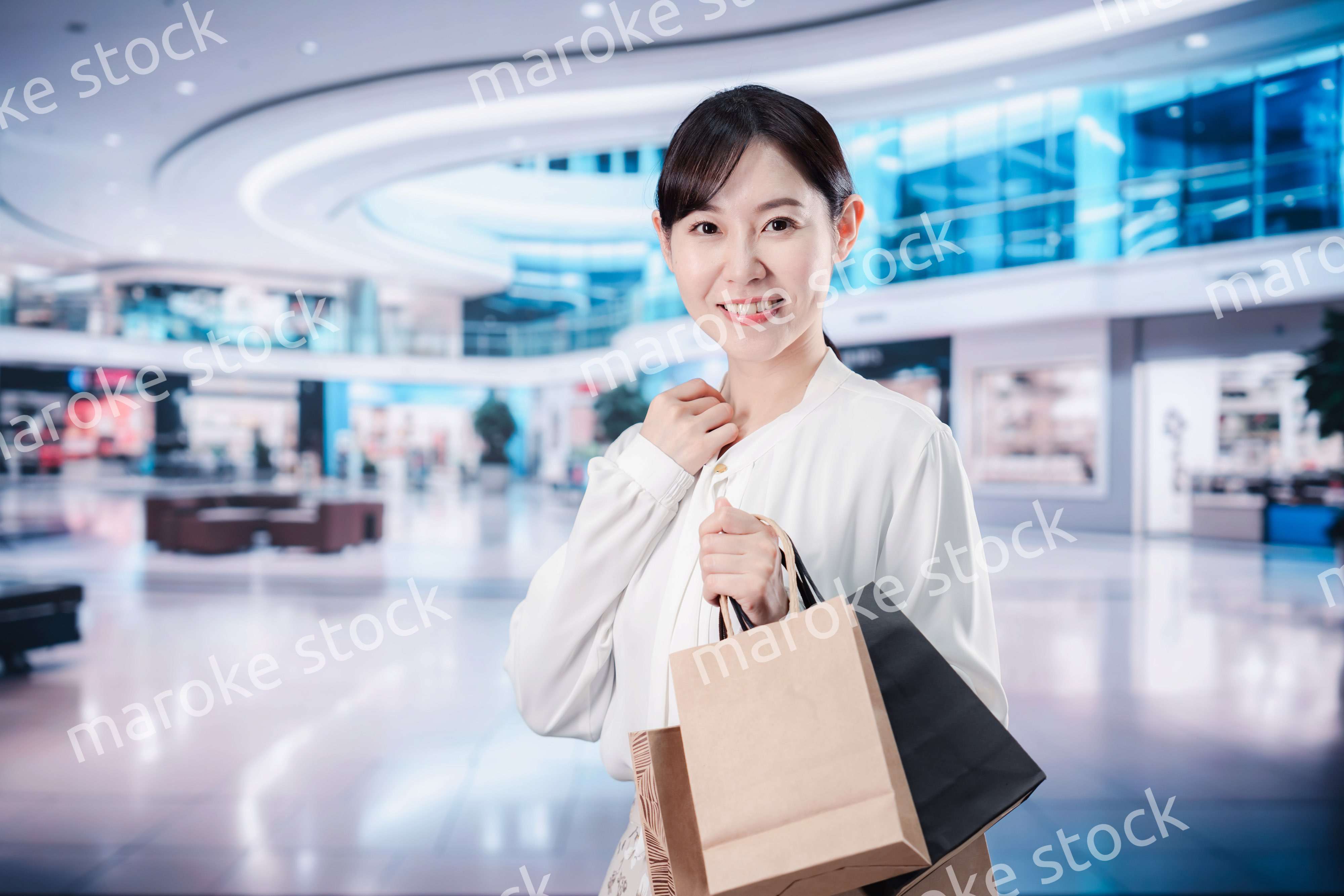 ショッピングモールで福袋を購入する若い女性